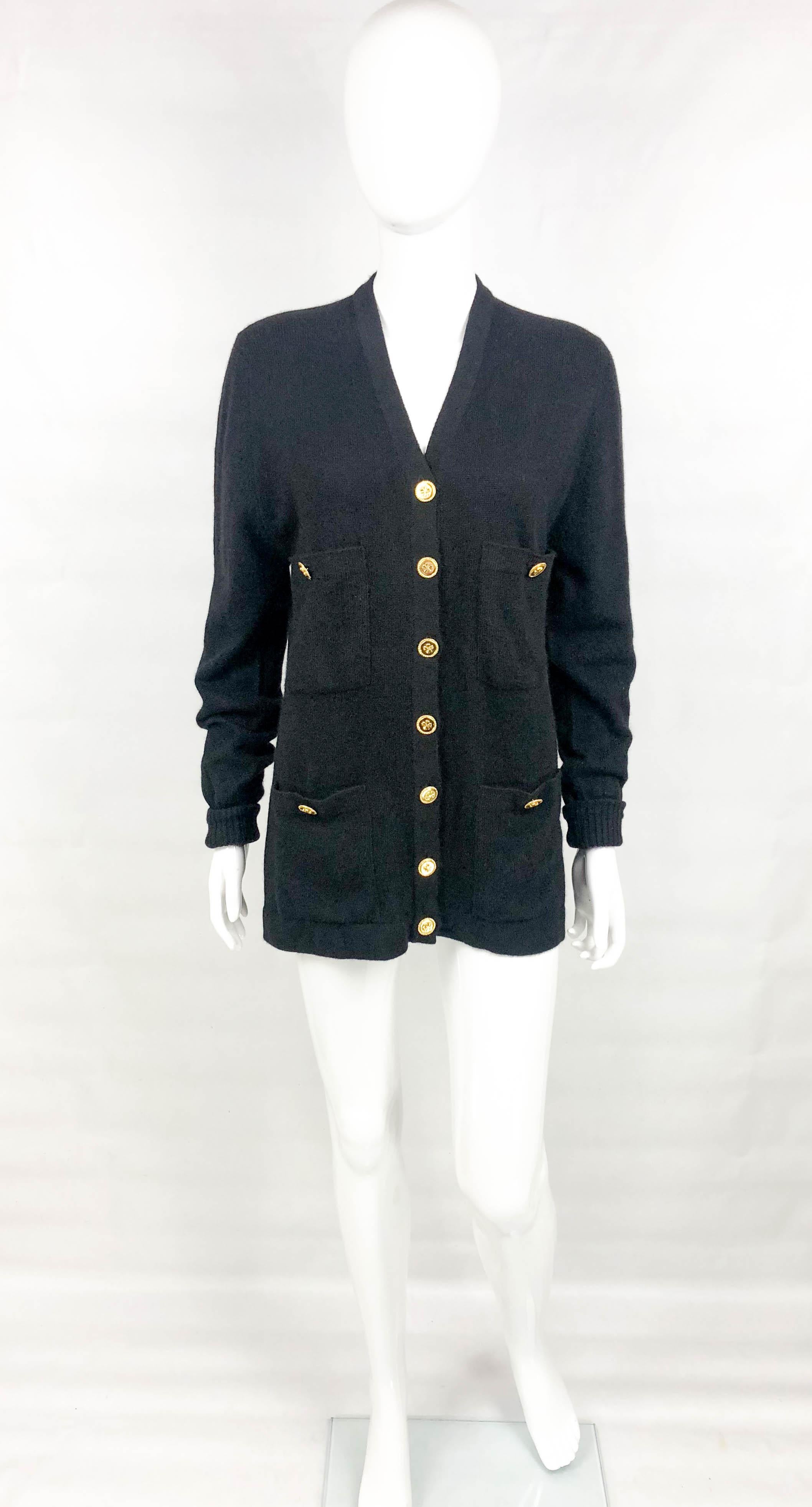 Vintage Chanel Black Cashmere Cardigan. This stylish cardigan by Chanel dates back from the 1990’s. Made in black cashmere, it features 4 front square pockets. The gilt buttons show a clover in the centre. A versatile piece for the chic