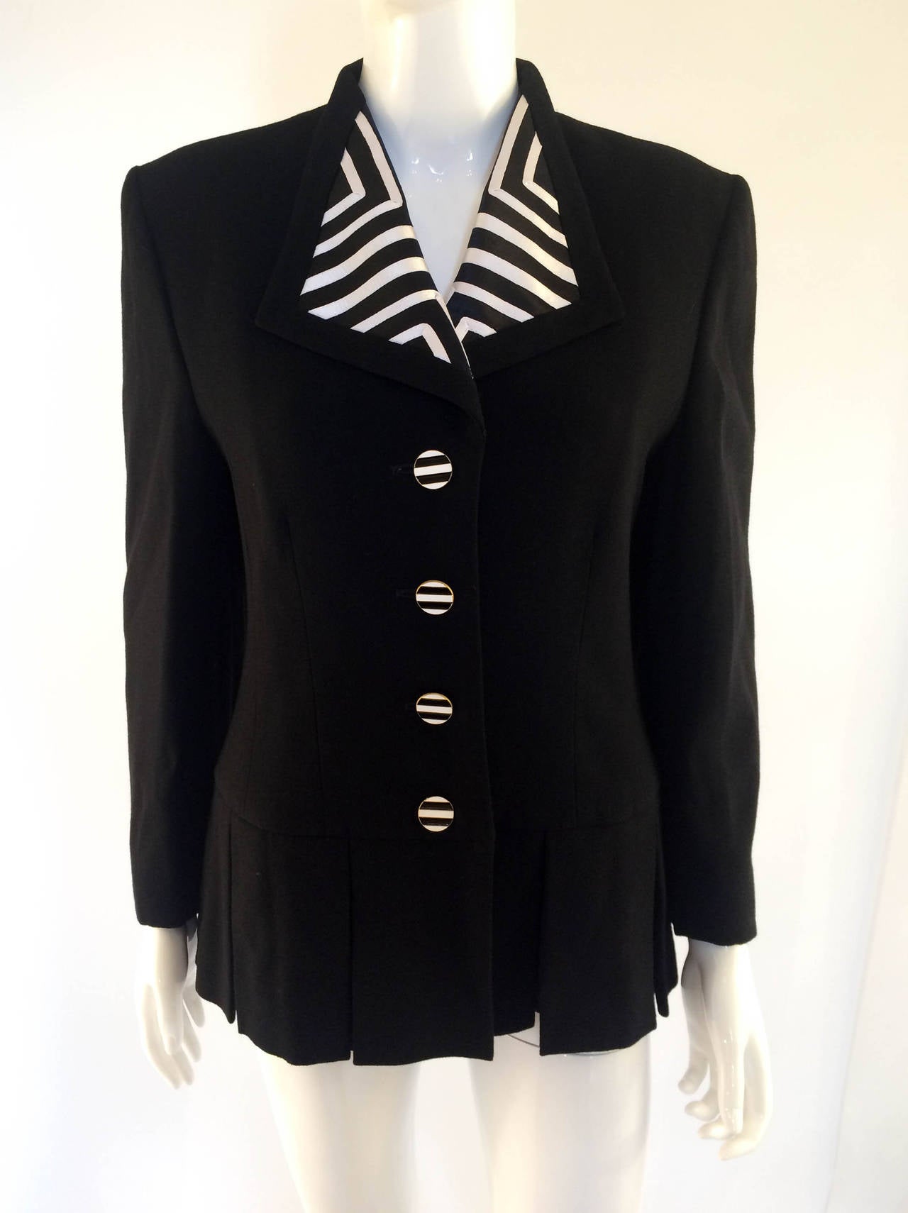 Very classy Vintage Louis Feraud Wool Jacket. This black jacket is single breasted, with a peplum of wide pleads creating a flattering silhouette. The lapel, back of the neck and the enamelled metal buttons are decorated with black and white