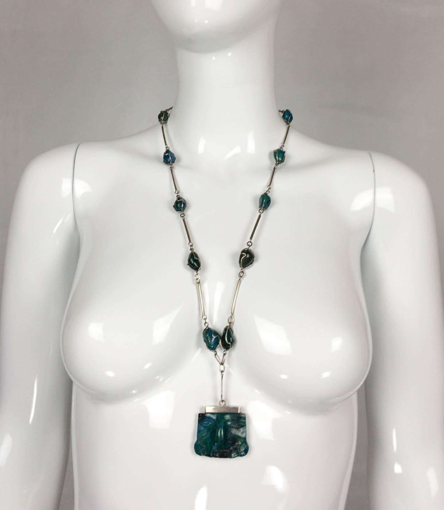 Very stylish Silver and Peruvian Turquoise Necklace. This piece is from South America from around the 1970s. The pendant is carved, featuring a face in Andes style. Great design!

Origin: South America (Andes)

Period: 1970s

Material: Silver