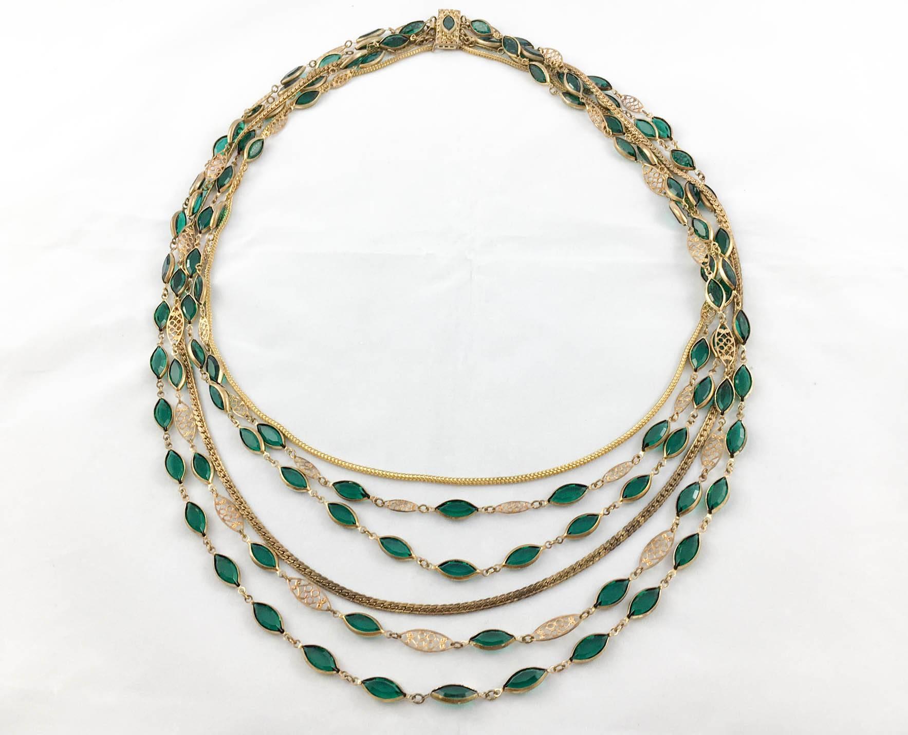 Striking Vintage Multi-Strand Necklace. This spectacular piece is made of 6 strings featuring green paste and gold-tone metal. This is a unique piece, probably from France and from the 1940s/1950s. It comprises different design aspects from the