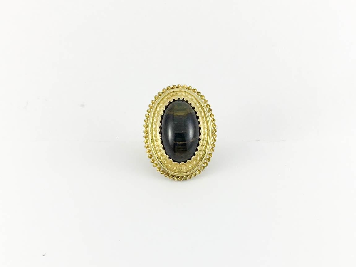 Dazzling Antique Gold and Tiger’s Eye Ring. This brooch conversion ring features a large and beautiful oval tigers eye stone and intricately worked gold on the top (shank is modern). Statement ring with lots of character.

Period: 1860s (the shank