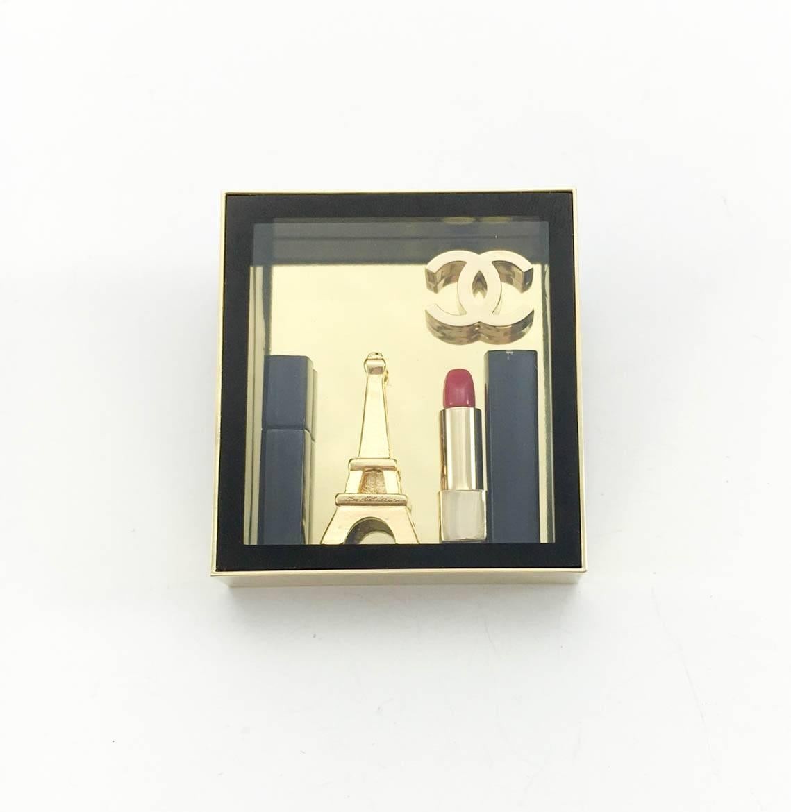 Very cute Chanel Brooch. This was probably a limited edition gift by Chanel that was never sold. The brooch features the iconic Eiffel Tower and Chanel ‘CC’ logo, as well as lipstick and mascara. It comes in its original box. This is a very fun