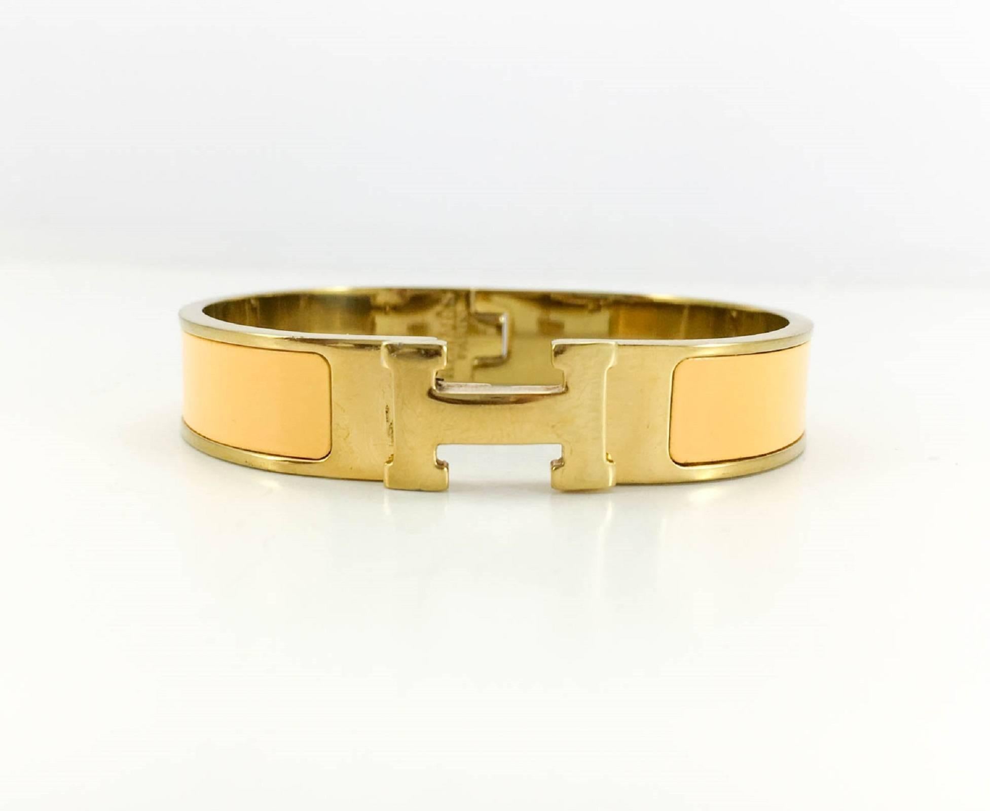 Hermes Clic Clac H Yellow and Gold Tone Bracelet. This very chic and elegant bracelet by Hermes features gilt hardware and yellow enamel. The clic clac clasp is in the shape of the Hermes iconic ‘H’. Understated and yet striking, this bracelet is