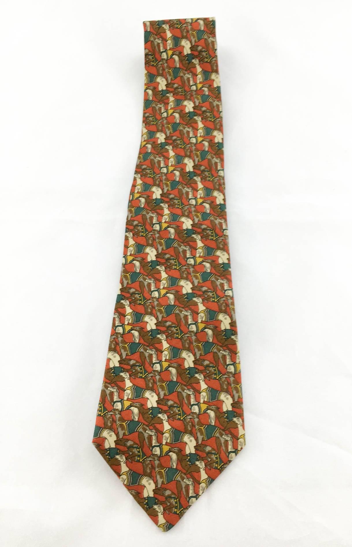 Elegant Salvatore Ferragamo ‘Racing Dogs’ Silk Tie. It features a great print of different racing dogs in different positions on a burnt red background. Perfect for dog lovers, this gorgeous tie will add quirkiness and character to any look.