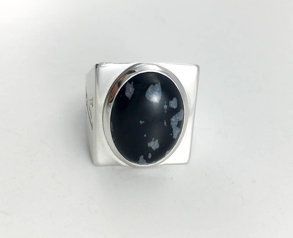Striking Louis Vuitton Silver and Obsidian Men’s Ring. This gorgeous ring by Louis Vuitton is part of the Snowflake collection and features a large oval black obsidian with grey ‘snowflake’ forms. The design of this substantial ring is geometrical
