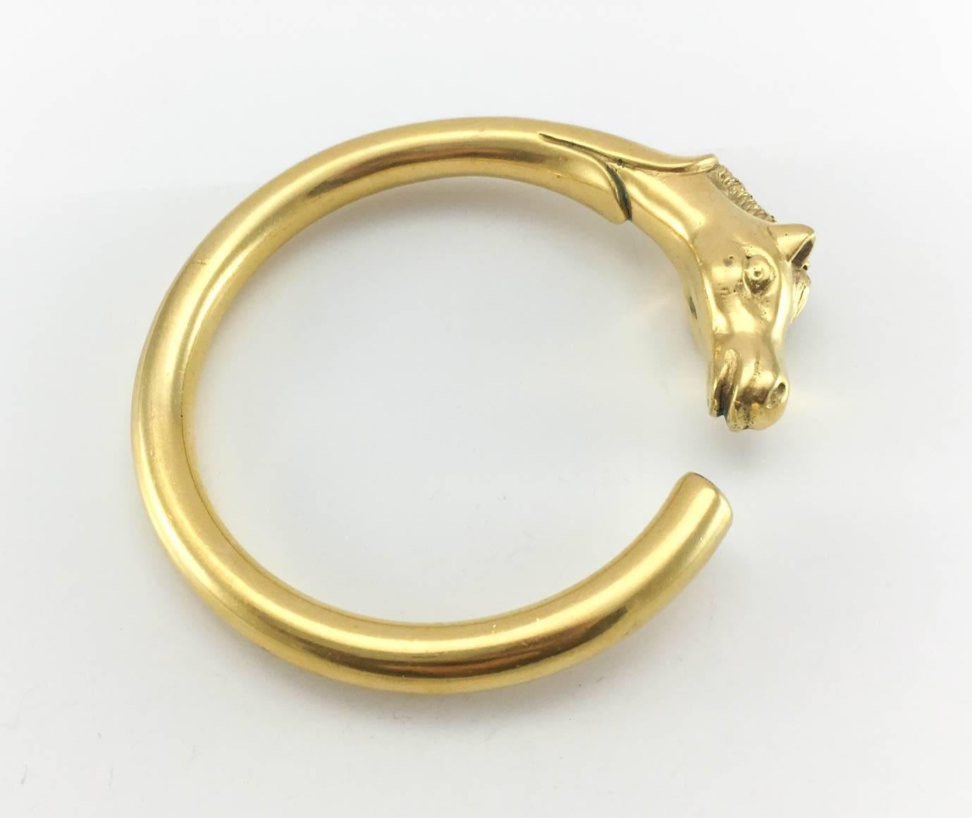 Vintage Hermes Horse Head Bangle. This gorgeous bracelet by Hermes is gold plated and dates back from the 1980s. The design features a beautifully crafted horse head on one end of a minimalist, clean-lined bangle. This piece pays homage to the