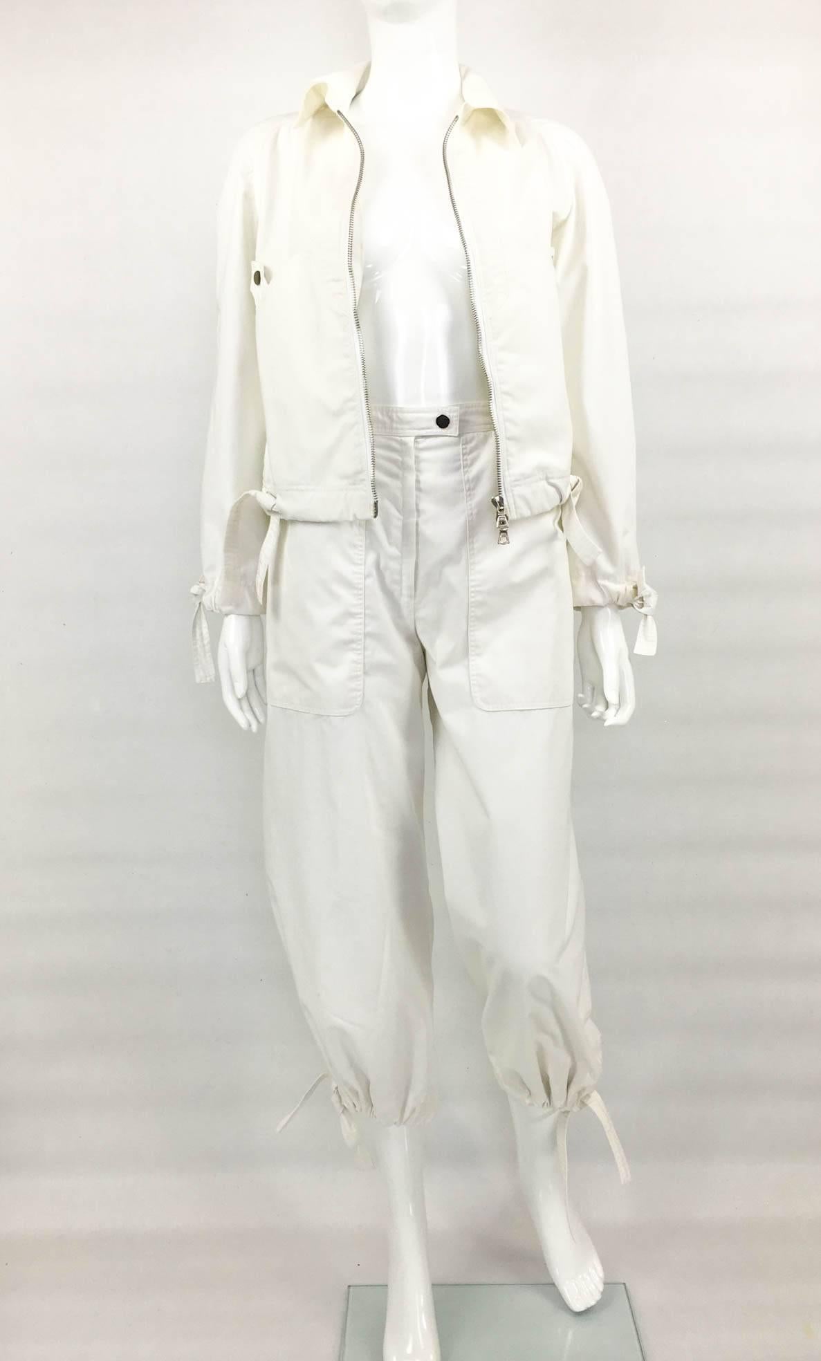 Uber Cool Vintage Courreges White Ensemble. This very stylish cotton-blend ensemble by Courreges dates back from the 1970s. Comprising of trousers and jacket, the adjustable ties in the jacket’s cuff and waist, as well as the pants’ hems, make it