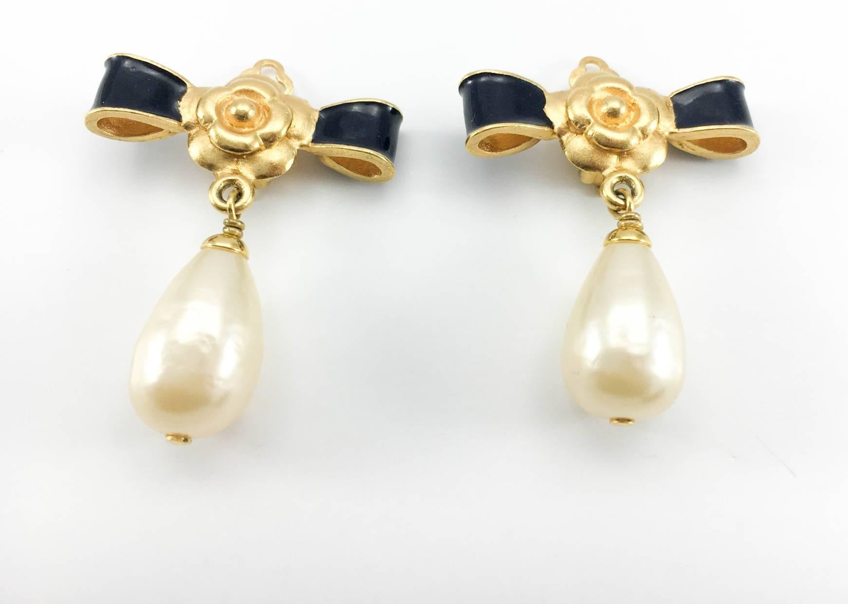 Gorgeous Vintage Chanel Camellia, Bow and Drop Pearl Clip-On Earrings. These fabulous earrings by Chanel are part of the 1993 Fall/Winter Collection. Gold-Plated, they feature an enamelled black bow with a gold-tone camellia (the flower of choice at