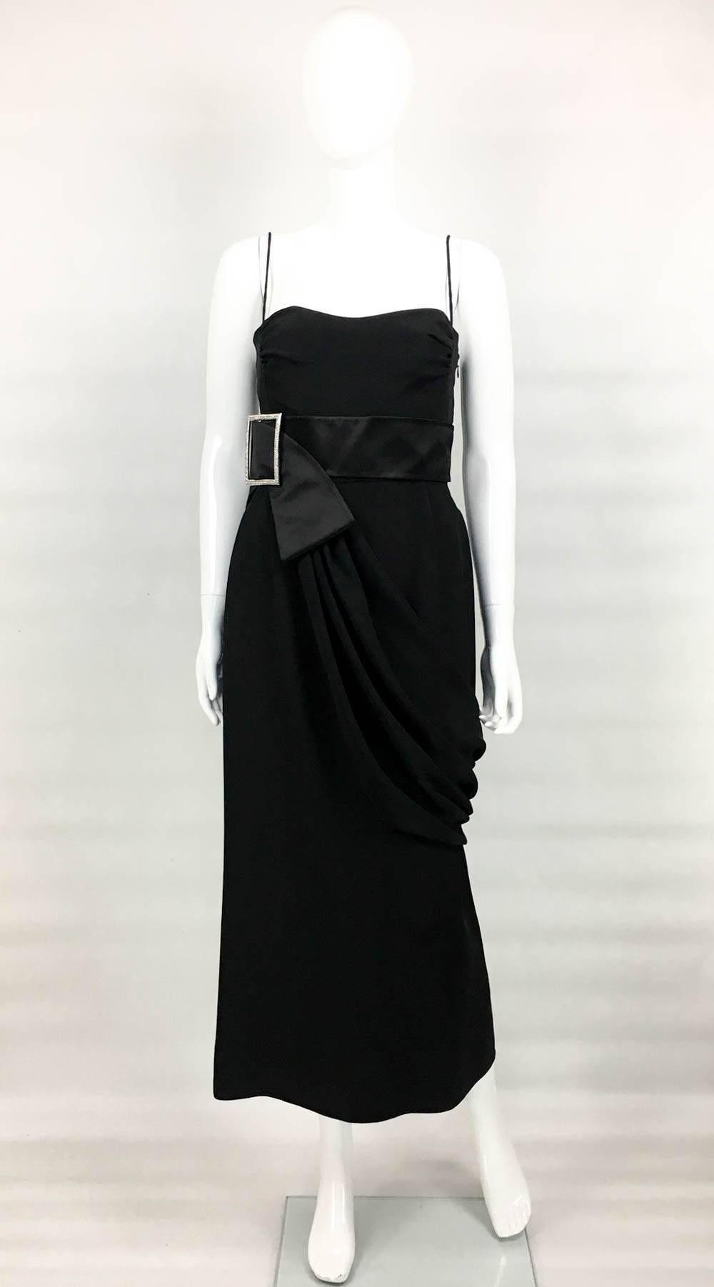 Chic Valentino Evening Dress. This stunning silk-blend dress by Valentino features a silver buckle with diamanté details on a satin sash and draping from the waist. It has an invisible side zipper and it is lined from the waist up. The silhouette