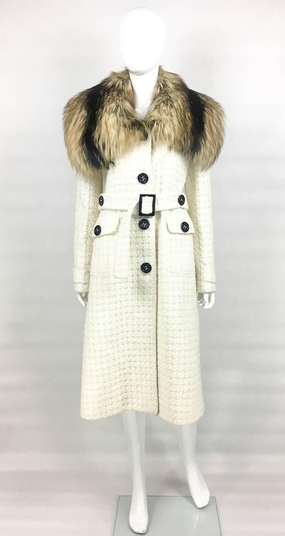 Beautiful Dolce & Gabbana Fur Collar Coat. This fabulous wool-blend off-white coat by Dolce & Gabbana features a dramatic fox-fur collar. The coat is mid-length and texturised. It has 4 buttons down the front, 2 pockets with buttons and a belt in