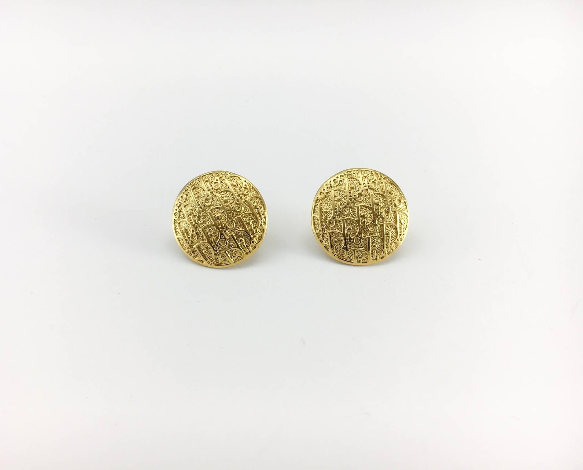 Very stylish trotter earrings by Dior. These stud earrings are made of gold-tone medallions with a repetitive pattern of the Dior logo. Dior singed on the back. In pristine condition, these earrings will add a touch of understated style and glamour