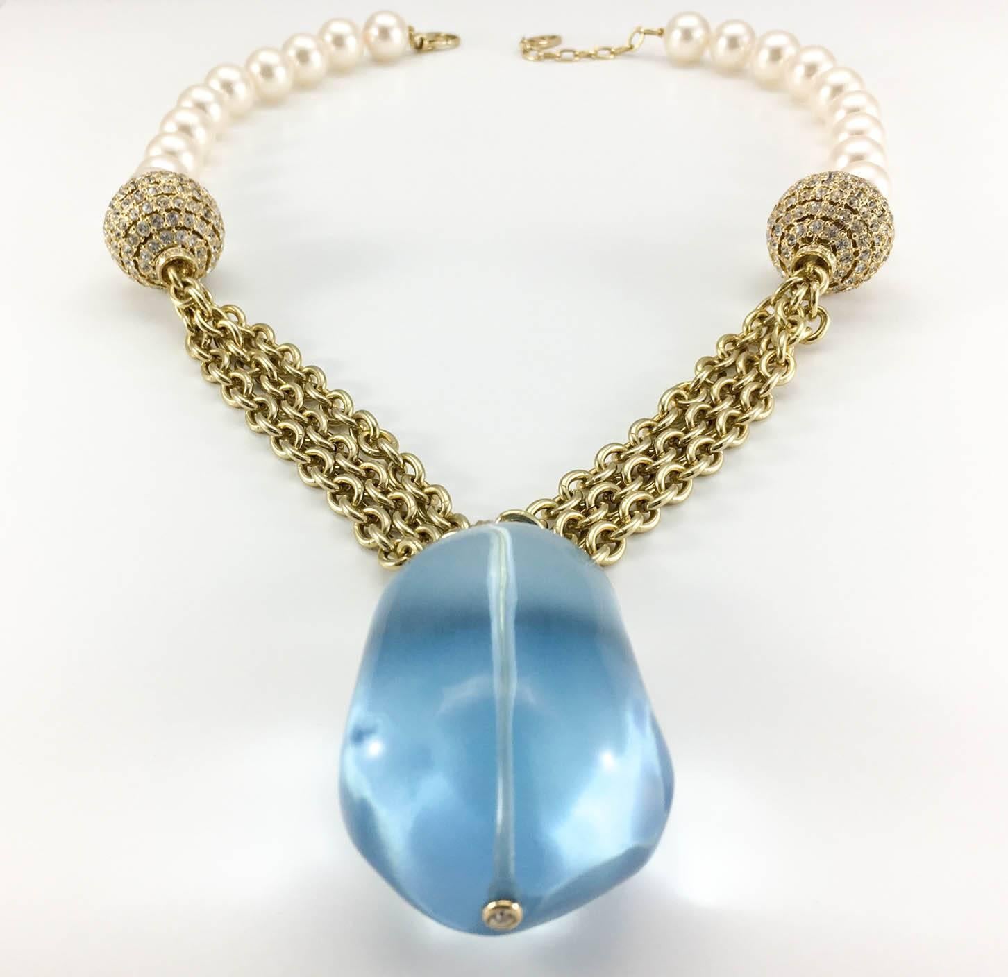 Striking Valentino Necklace. This Valentino creation is certainly a statement piece. It features a large pale blue transparent resin pendant, the necklace itself is made half in glass pearls and the other half in gold-tone chains, with a rhinestone