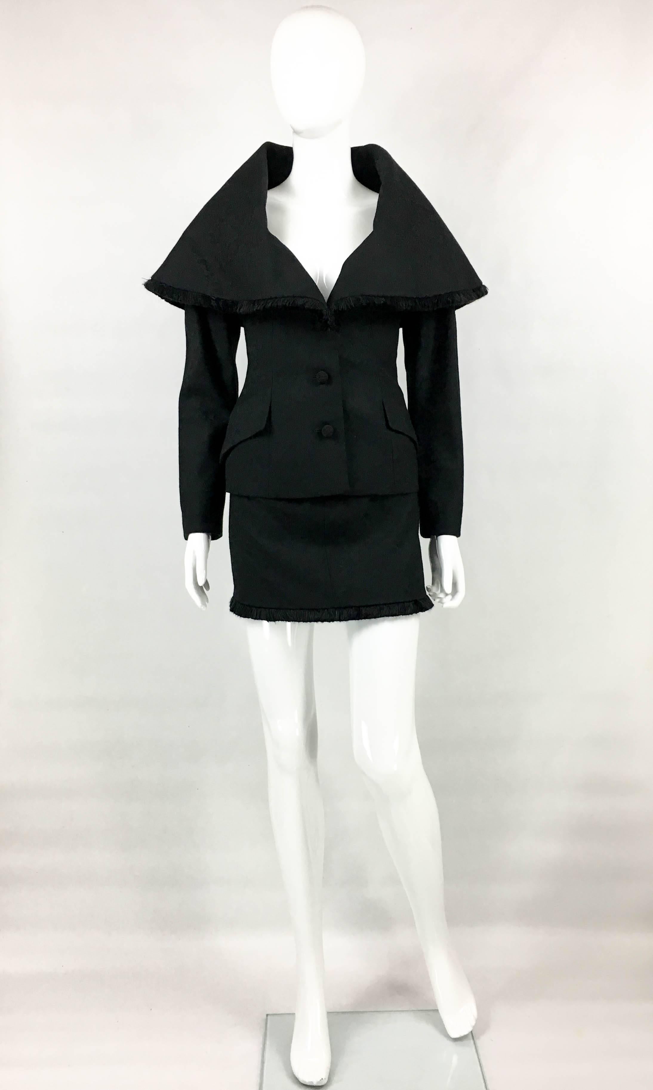 Important Vintage Dior Black Skirt Suit. This fabulous Dior by John Galliano ensemble consists of a jacket with dramatic collar and a daring mini-skirt, resulting in an explosion of elegance and sexiness. The same model appears in the Dior add