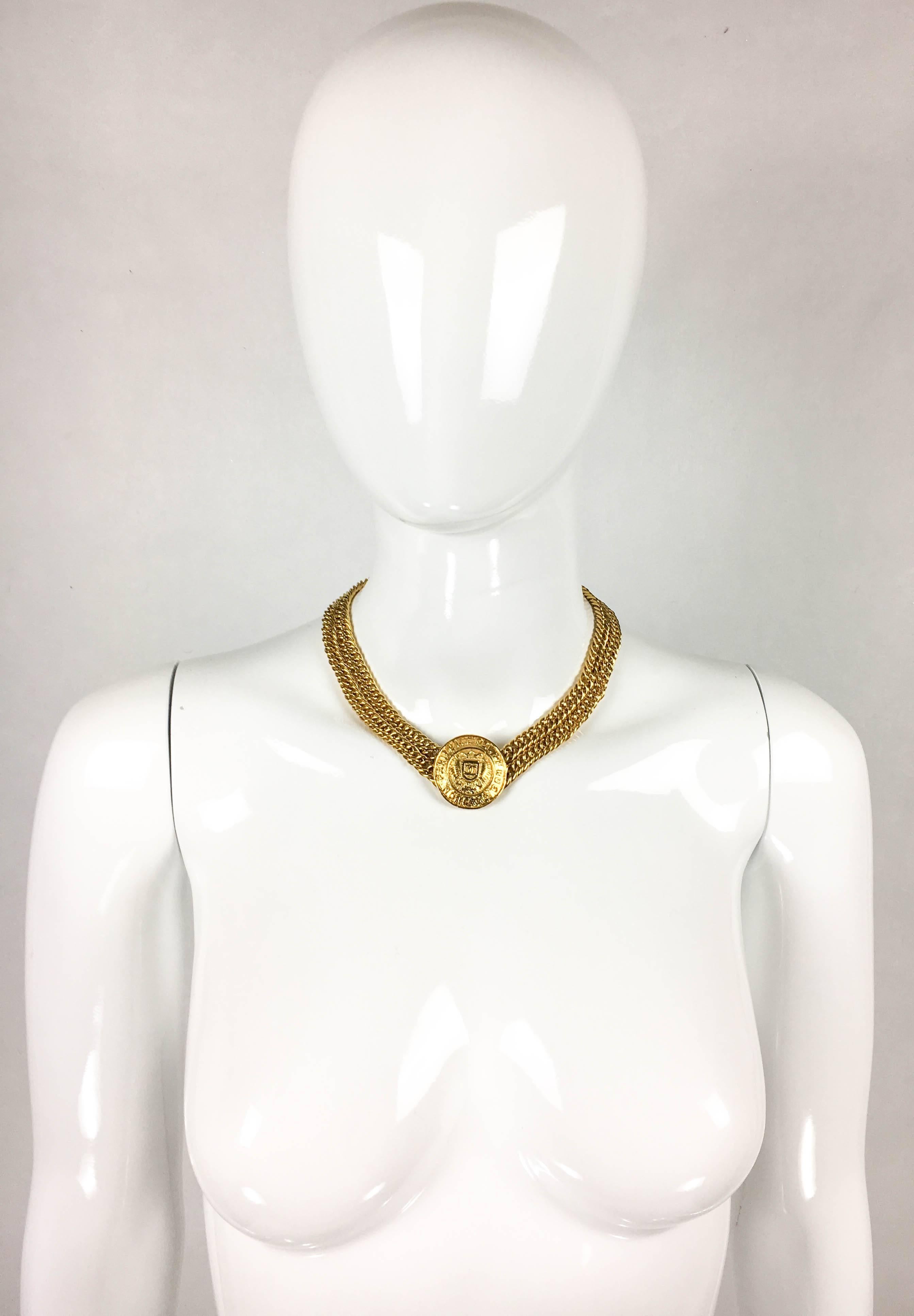 Stylish Vintage Chanel Gold-Tone Medallion Necklace. This beautiful piece by Chanel dates from the early 1990’s. It features a double chain with the coin medallion as a pendant. The medallion resembles hammered gold, and reads ’Chanel 31 Rue Cambon
