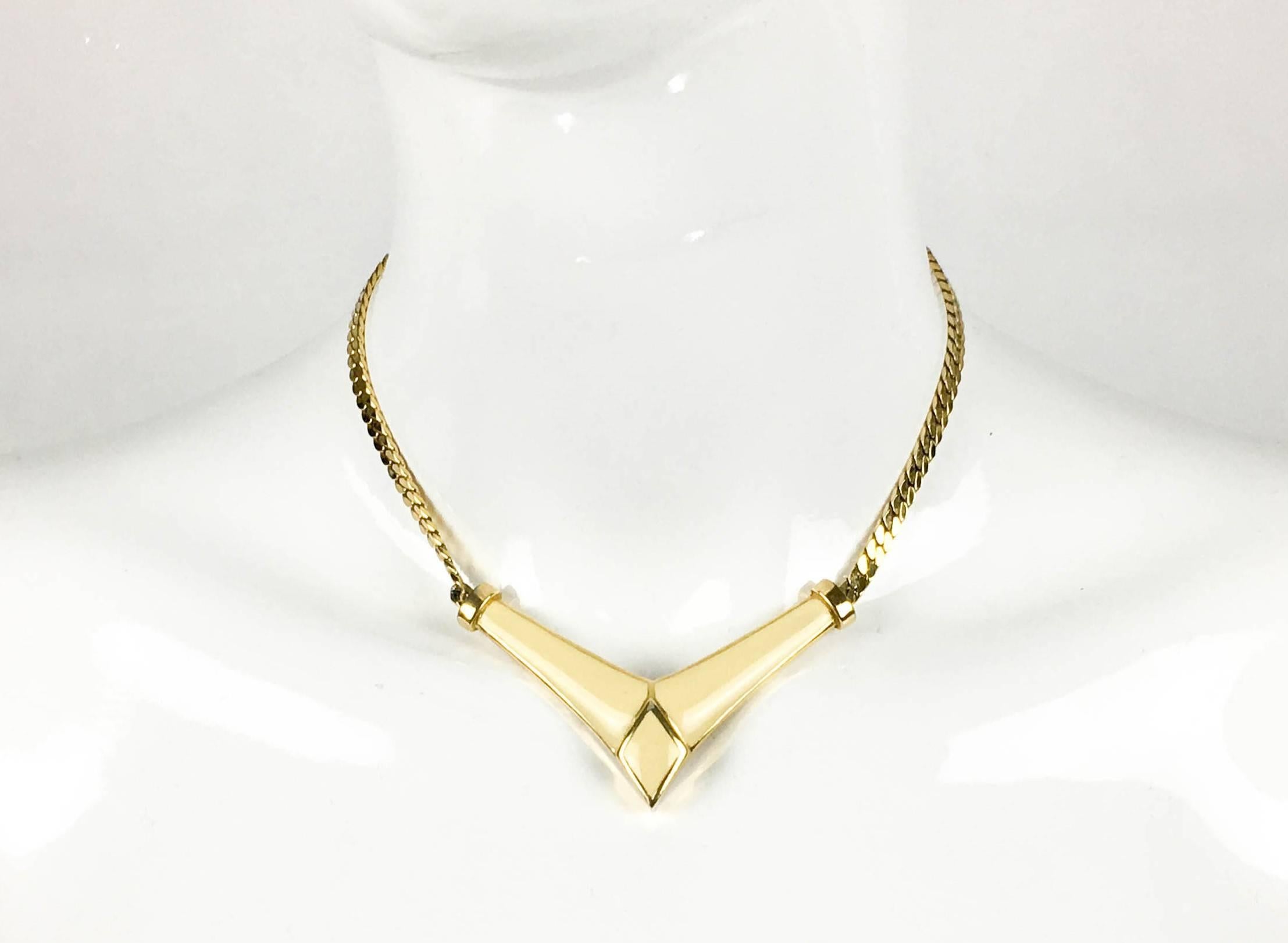 Stylish Vintage Dior Necklace. This necklace by Christian Dior was made in Germany in the 1980’s. It features a chain with a pendant style detail adorned with off-white/ivory enamelled in geometric shapes. Gold-tone hardware. Christian Dior (CD)