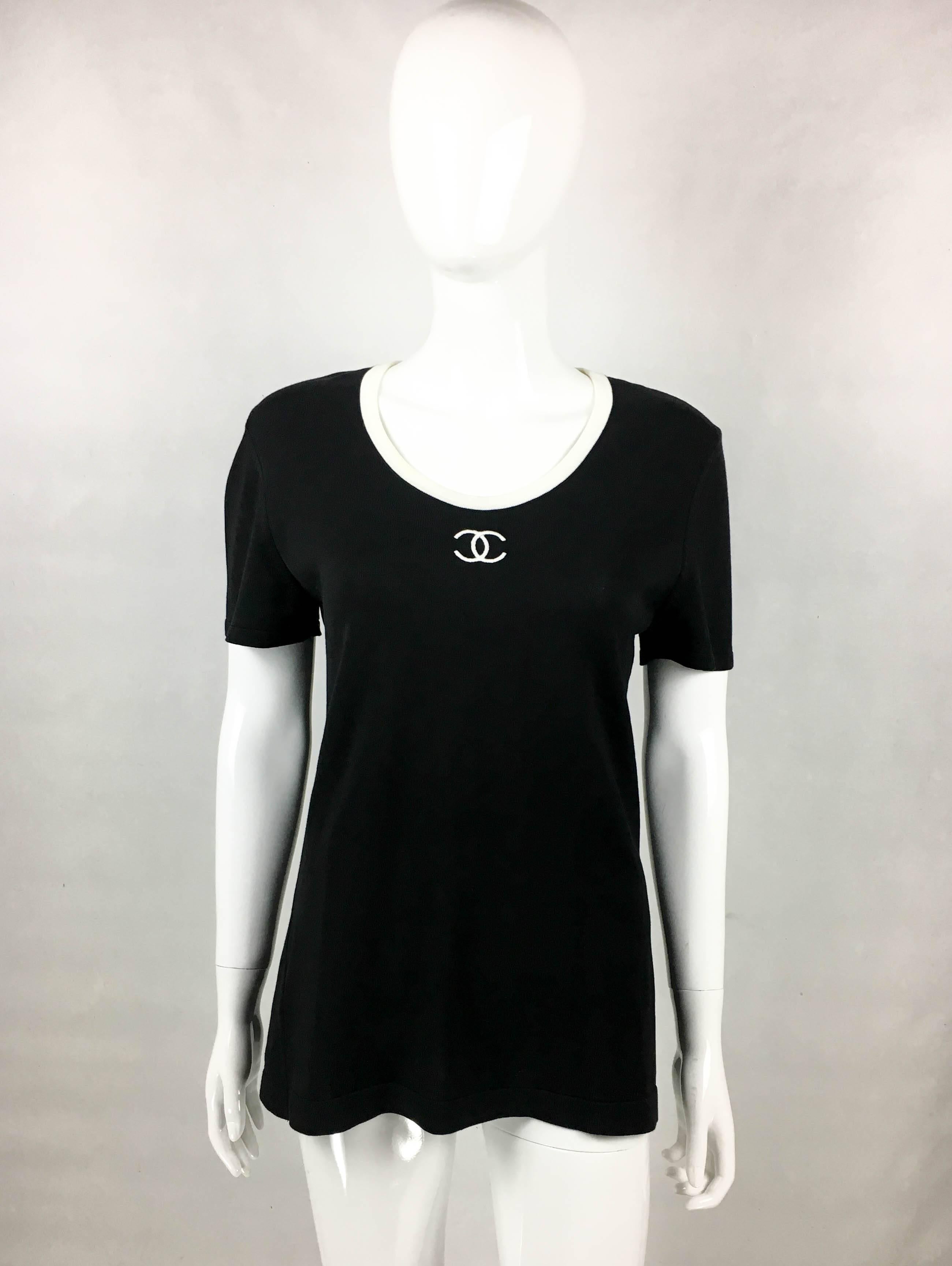 Vintage Chanel Logo Black T-Shirt. Made in black cotton jersey, this 1990’s Chanel short-sleeves T-shirt is perfect for a casual, yet chic look. With contrasting collar, it features the iconic Chanel ‘CC’ logo in white on the front. For the cool and