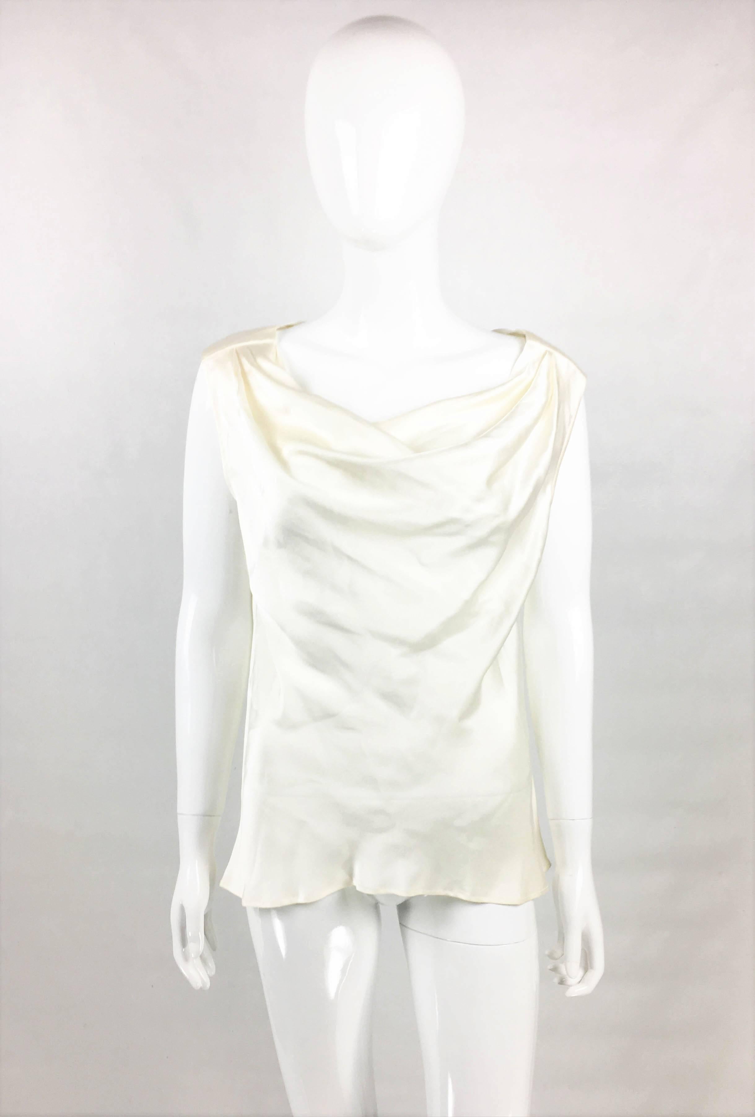Vintage Yves Saint Laurent Rive Gauche White Silk Blouse. This pretty sleeveless blouse by Yves Saint Laurent dates back from the 1990’s. Made in white silk, it romantically drapes on the front and back. This chic and timeless piece is perfect for
