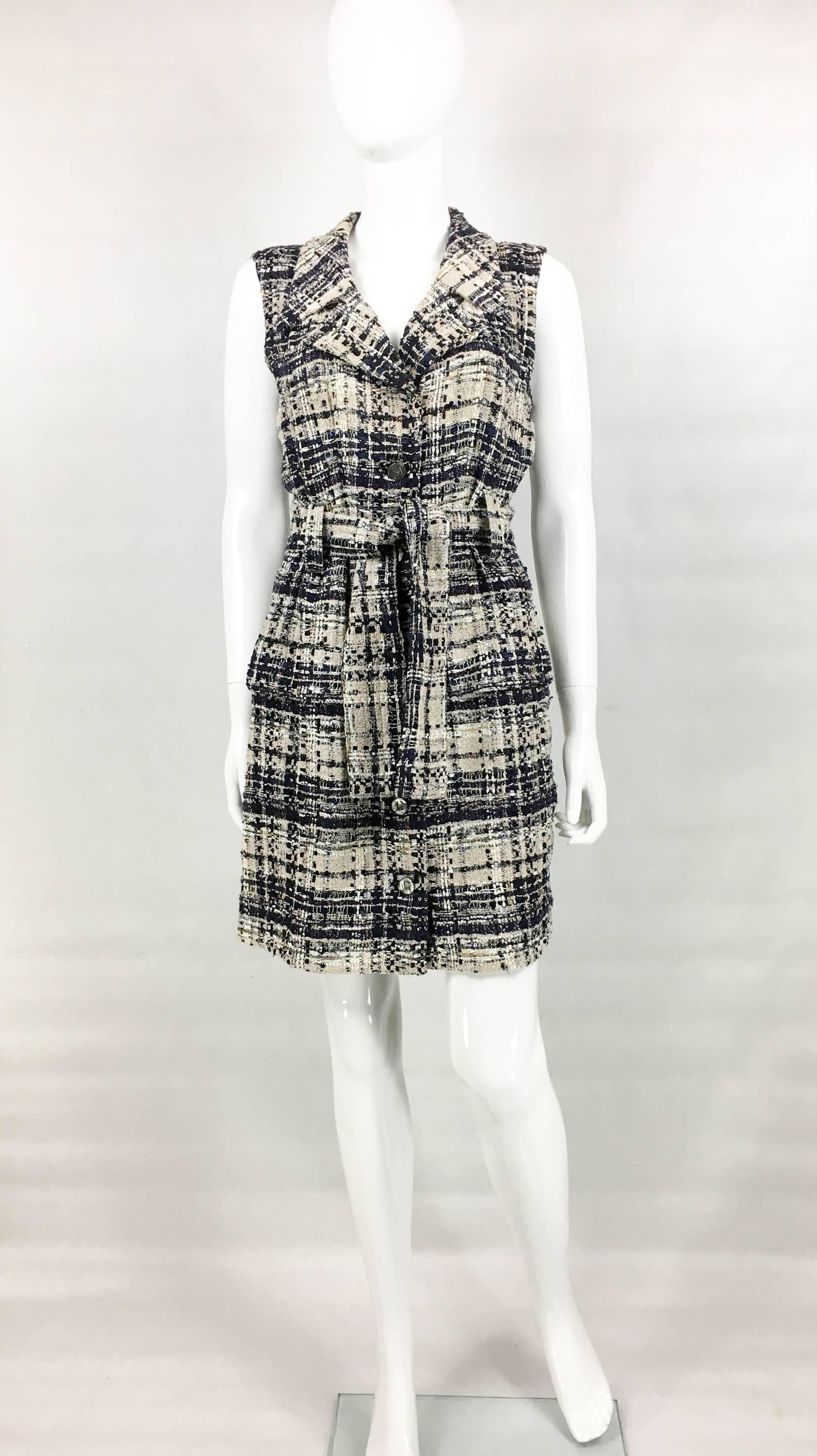 Chanel Belted Bouclé Shirt Dress. This striking dress by Chanel was created for the 2006 Spring / Summer Collection. Made in tweed bouclé masterfully blending black, navy, cream, silver, gold and bronze accents. There are 6 silver tone coin buttons