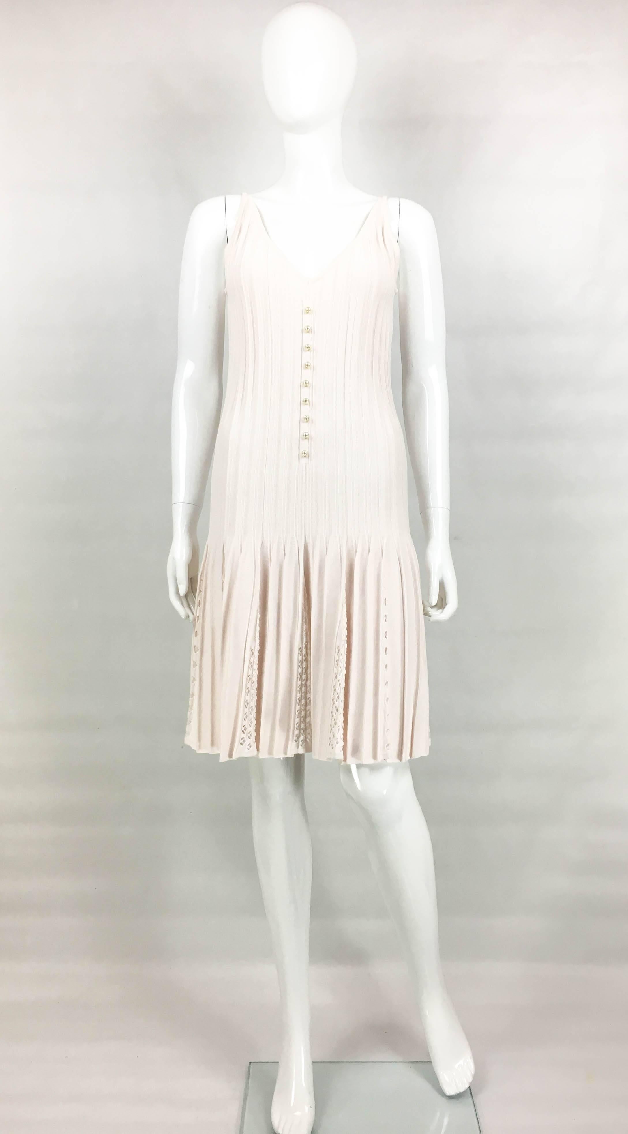 Chanel Pale Pink Summer Dress. This flirty cotton-blend dress by Chanel was part of the 2012 Spring / Summer Collection. With straps and ribs body, it flares out to a pleated skirt from the hips down creating a very flattering silhouette. The skirt