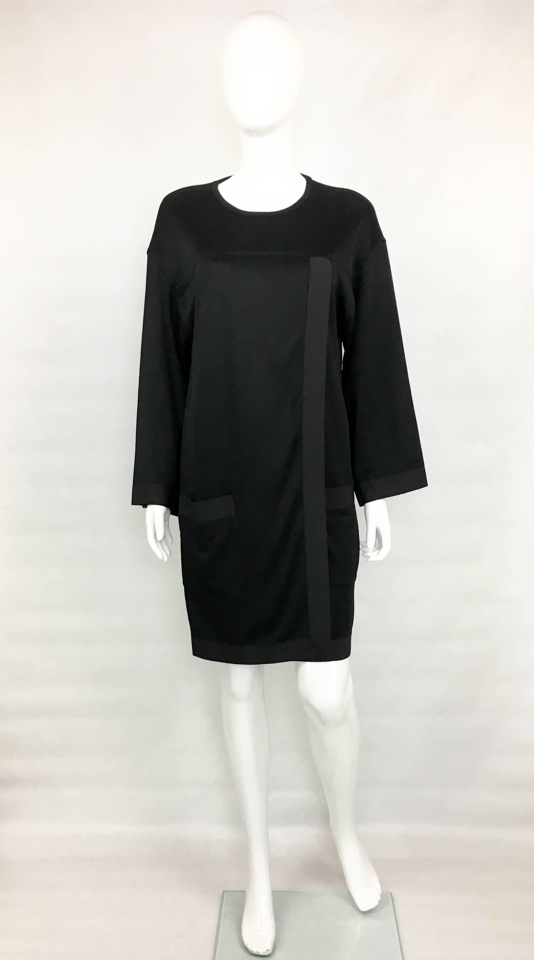 Vintage Chanel Black Jumper Dress. Dating back from the 1990’s, this jumper dress brings a nonchalant approach to fashion. Made in non-stretchy rayon jersey, it features grosgrain trims, round neckline and bracelet sleeves. It has a loose shape and