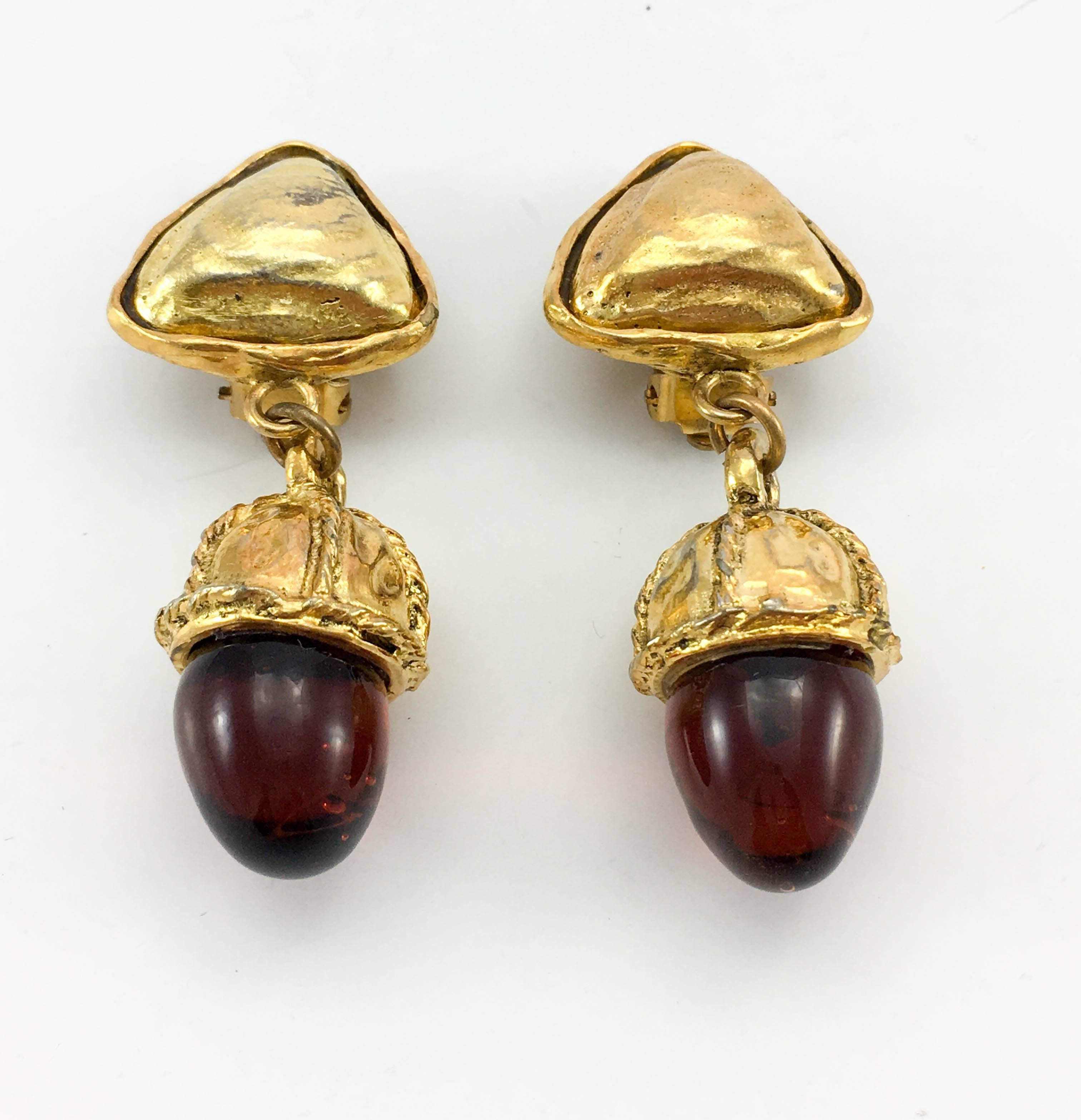 Vintage Chanel Red Gripoix Acorn Dangling Gilt Clip-On Earrings. These striking earrings by Chanel date back from the 1970’s. The top part of the earring is a triangle with the acorn-like bottom part hanging from it. The metalwork has an organic