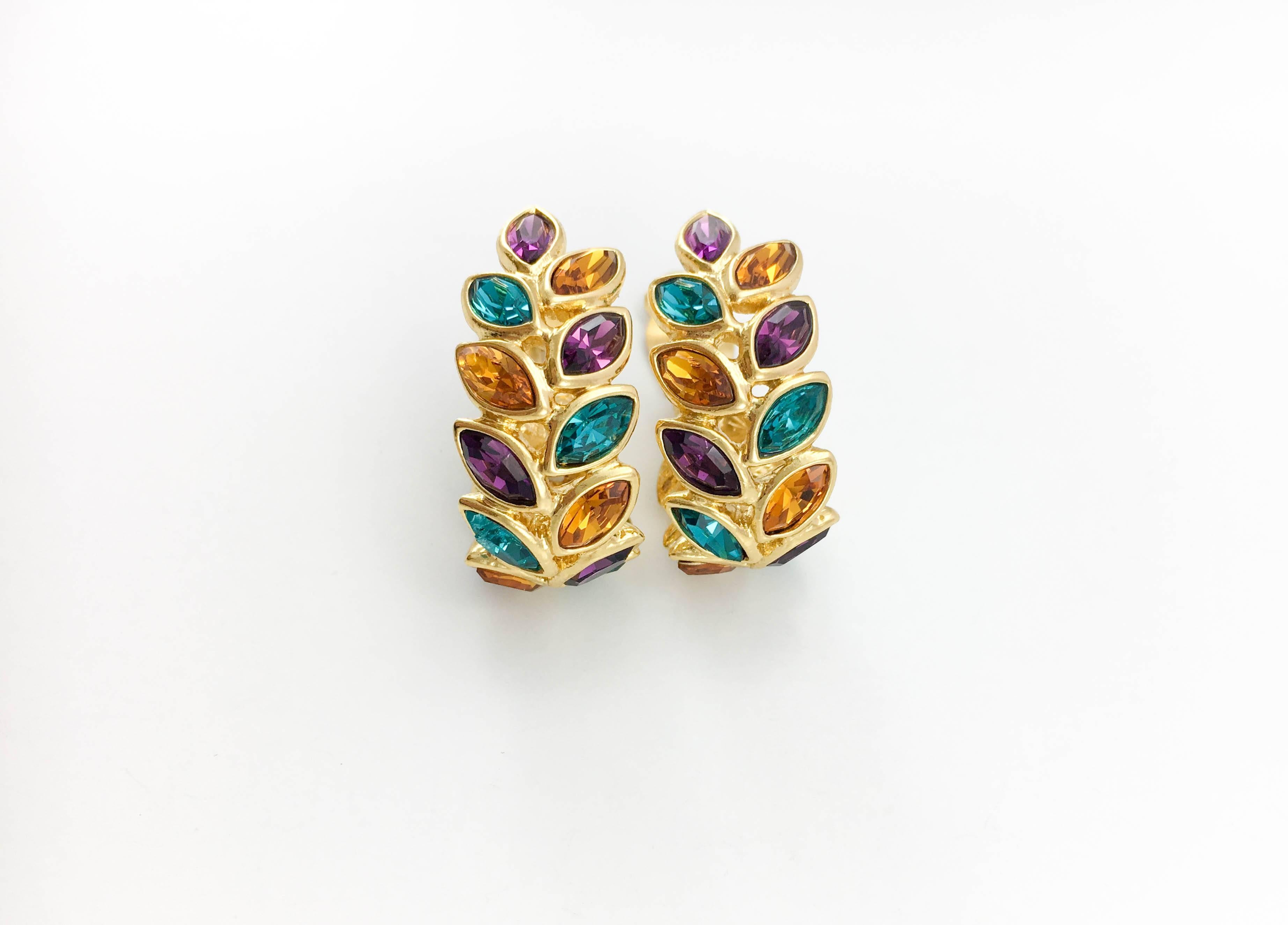Vintage Yves Saint Laurent Multi-Coloured Glass Beads Clip-On Earrings. These beautiful earrings by Yves Saint Laurent date back from the 1980’s. In gilt metal, they are embellished with blue, red, purple, amber and green leaf-shaped crystals. The