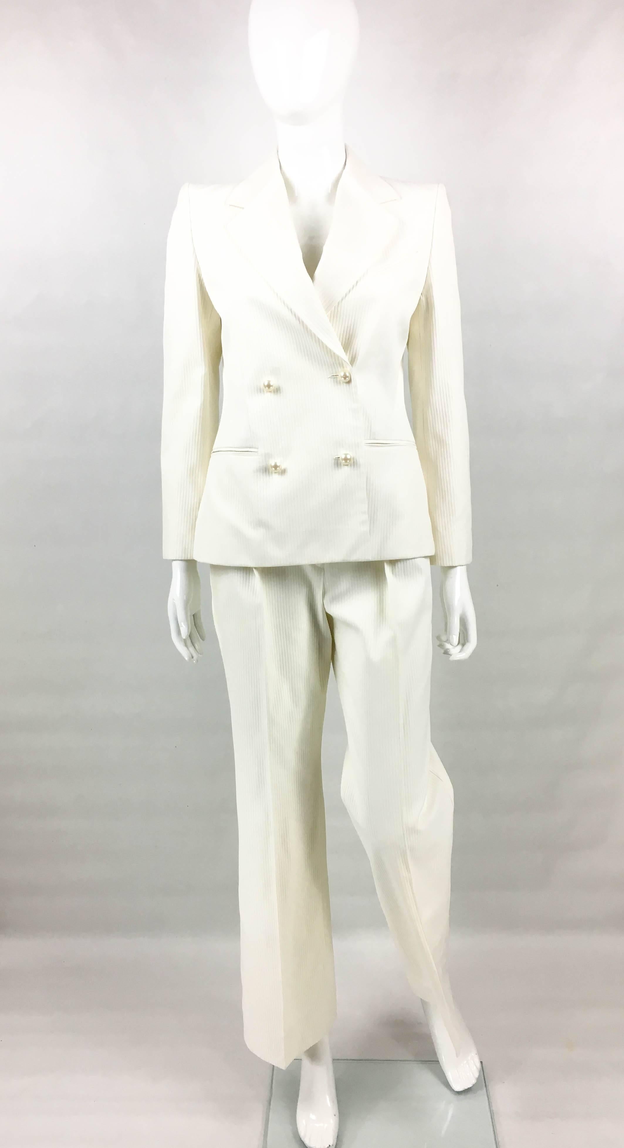 Vintage Chanel White Trouser Suit with Pearl Buttons. This stunning suit by Chanel was created for the 2001 Spring / Summer Runway Show. An identical suit is seen being worn by a model on the runway (refer to photos). Made in white ribbed cotton