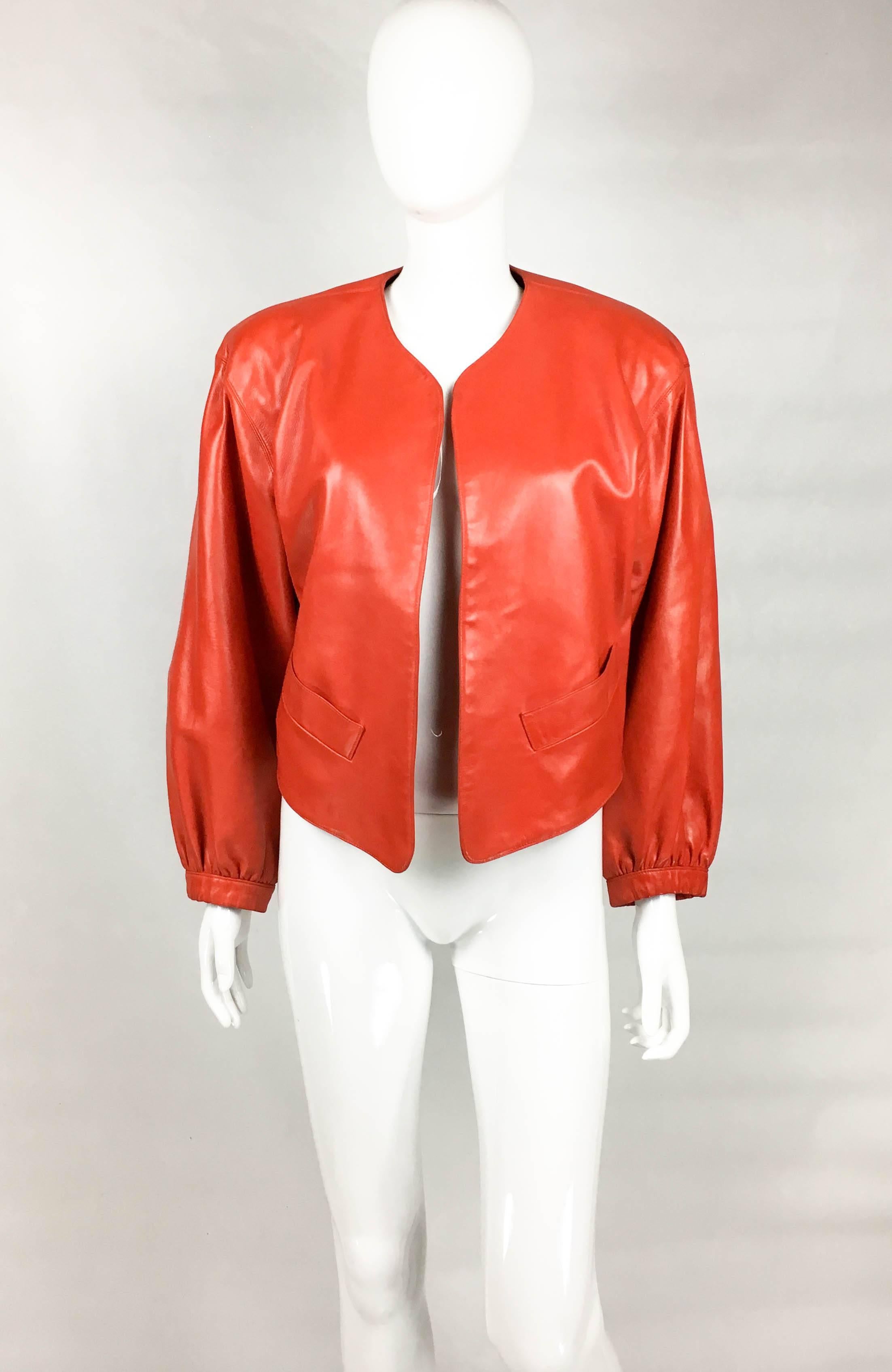 Vintage Yves Saint Laurent Red Leather Jacket. This gorgeous piece by Yves Saint Laurent dates back from the 1980’s. Crafted in butter soft red leather, it features voluminous sleeves and cropped back. There is no closure to the front, allowing for
