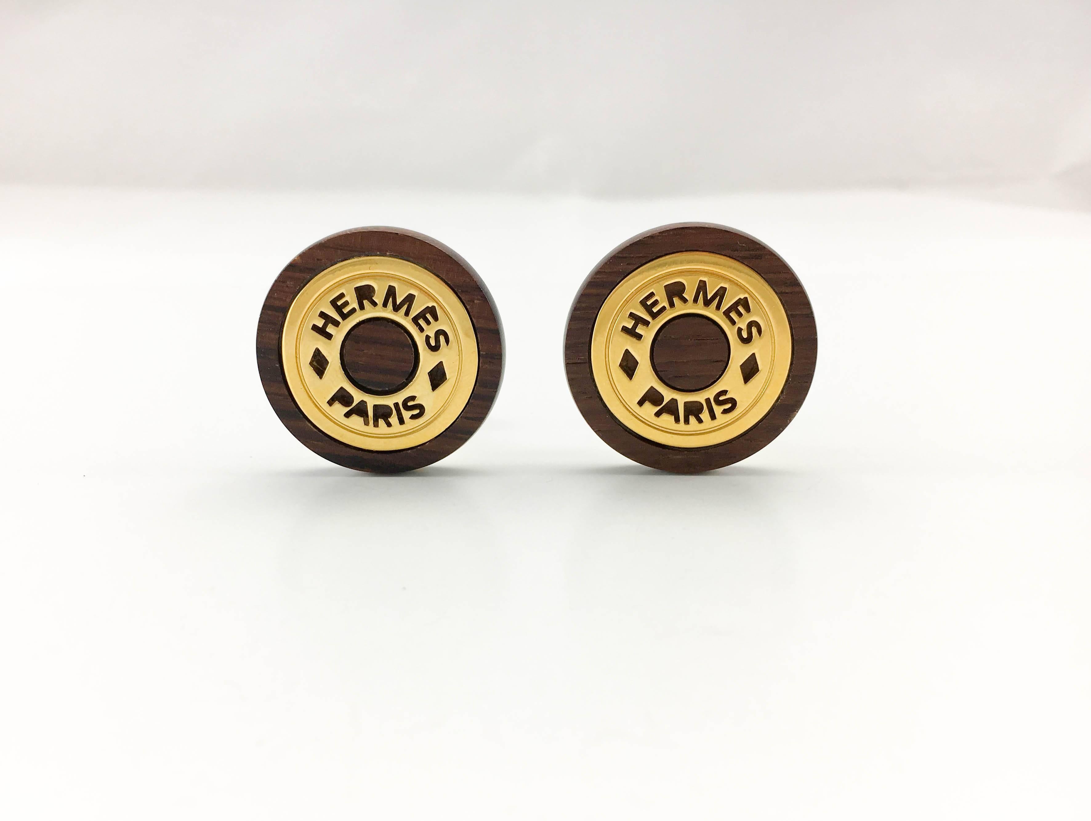Vintage Hermes Wood and Gold-Plated Clip-On Earrings. Dating from the 1990’s these earrings by Hermes are a great way to add timeless style to a look. Made in wood and gold-plated base metal, they are round and read ‘Hermes Paris’. Hermes signed on