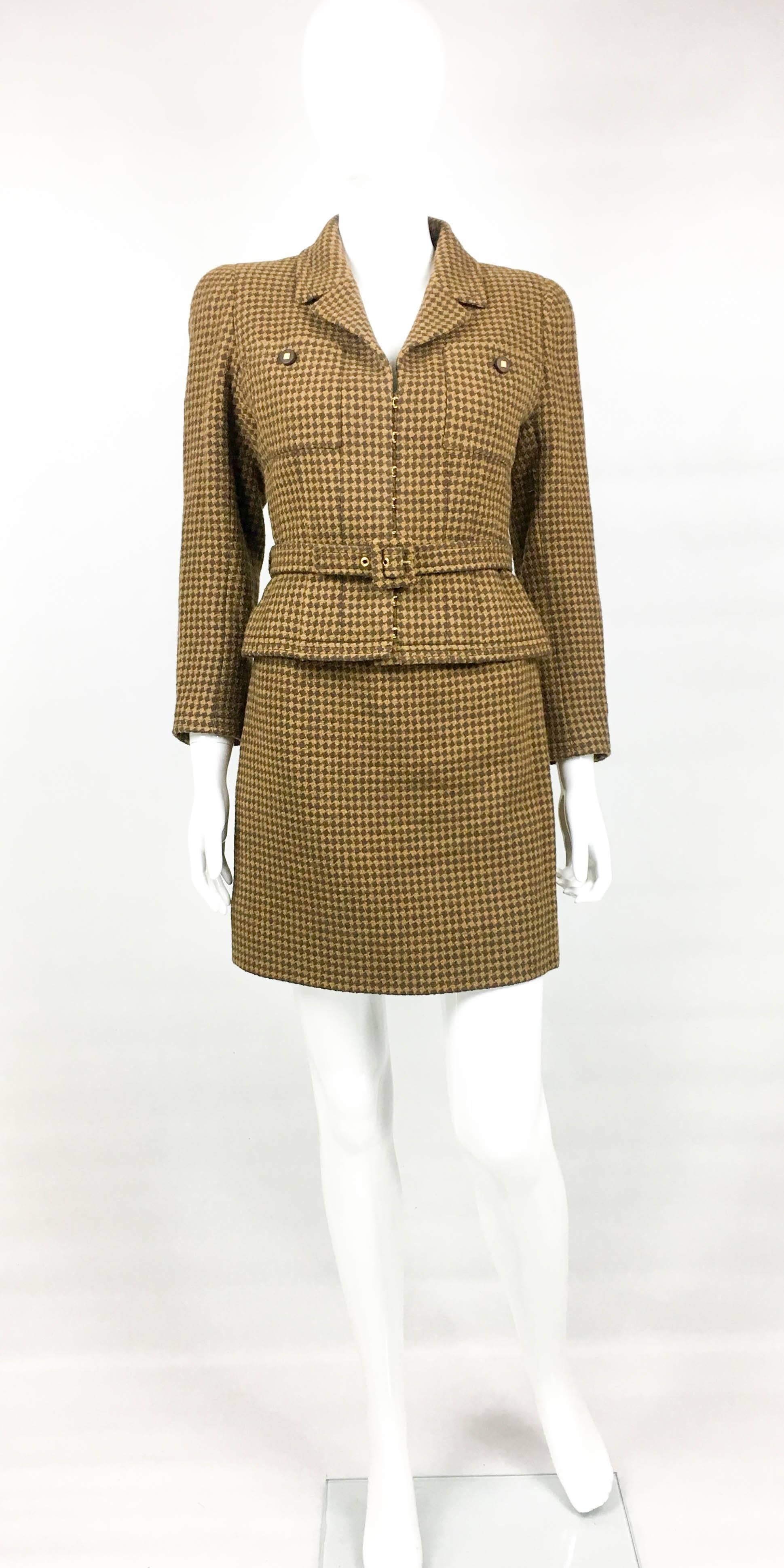 Vintage Chanel Brown Houndstooth Skirt Suit. This beautiful suit by Chanel is from the 1996 Autumn / Winter Collection. Crafted in brown wool houndstooth, it comprises a short skirt and fitted jacket. Both pieces are lined in silk. The jacket