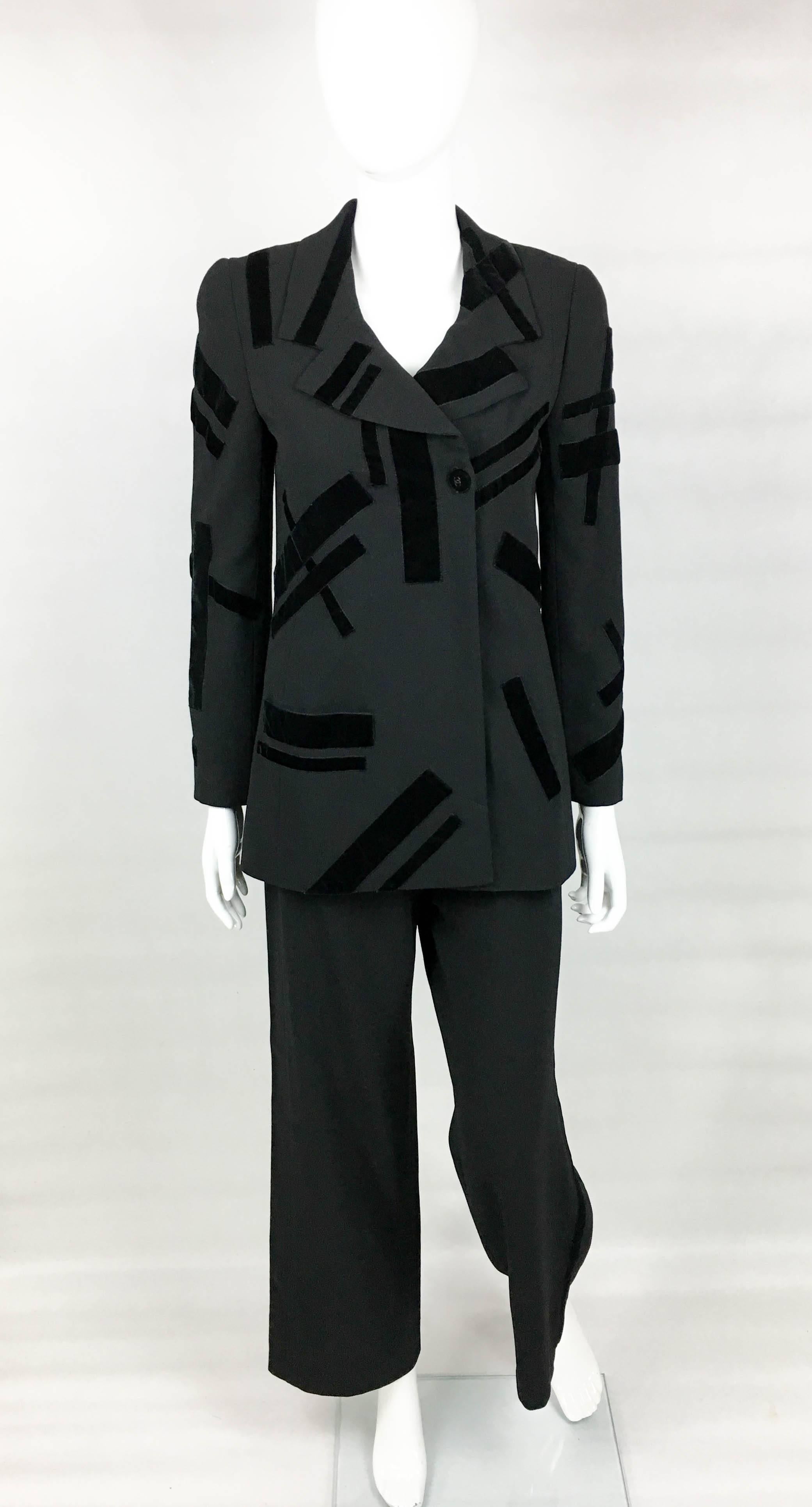 Vintage Chanel Black Trouser Suit with Velvet Details. This stylish suit by Chanel dates back from 1998. Made in light wool, it is lined in silk. The jacket is lined in silk, has two pockets and various geometrically shaped velvet details. The