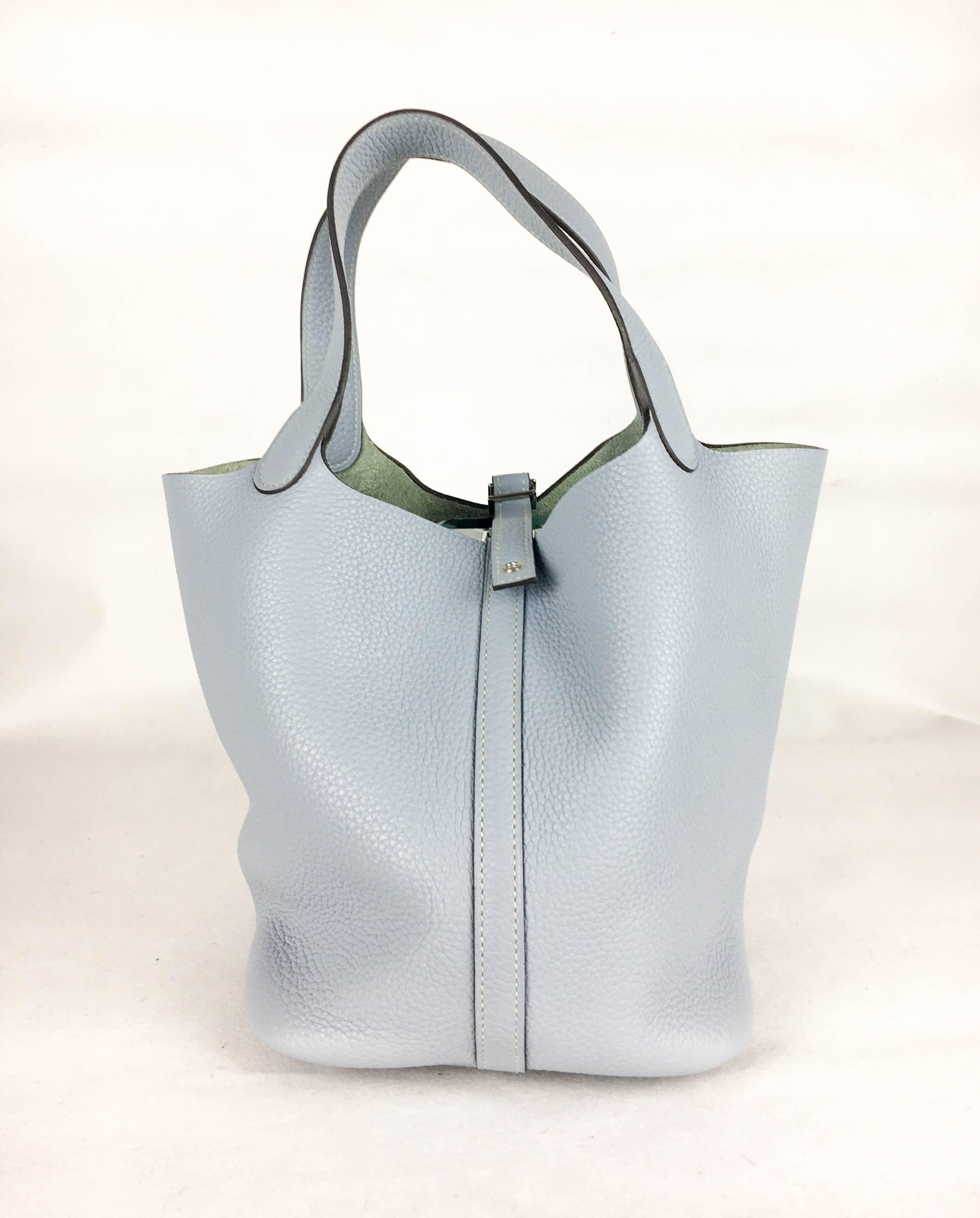 Gorgeous Hermes Picotin Lock Handbag. In pale blue clemence leather and palladium hardware, this is a very stylish handbag by Hermes. This handbag originally came with the lock to attach at the end of the strap, but, unfortunately, it has been lost.