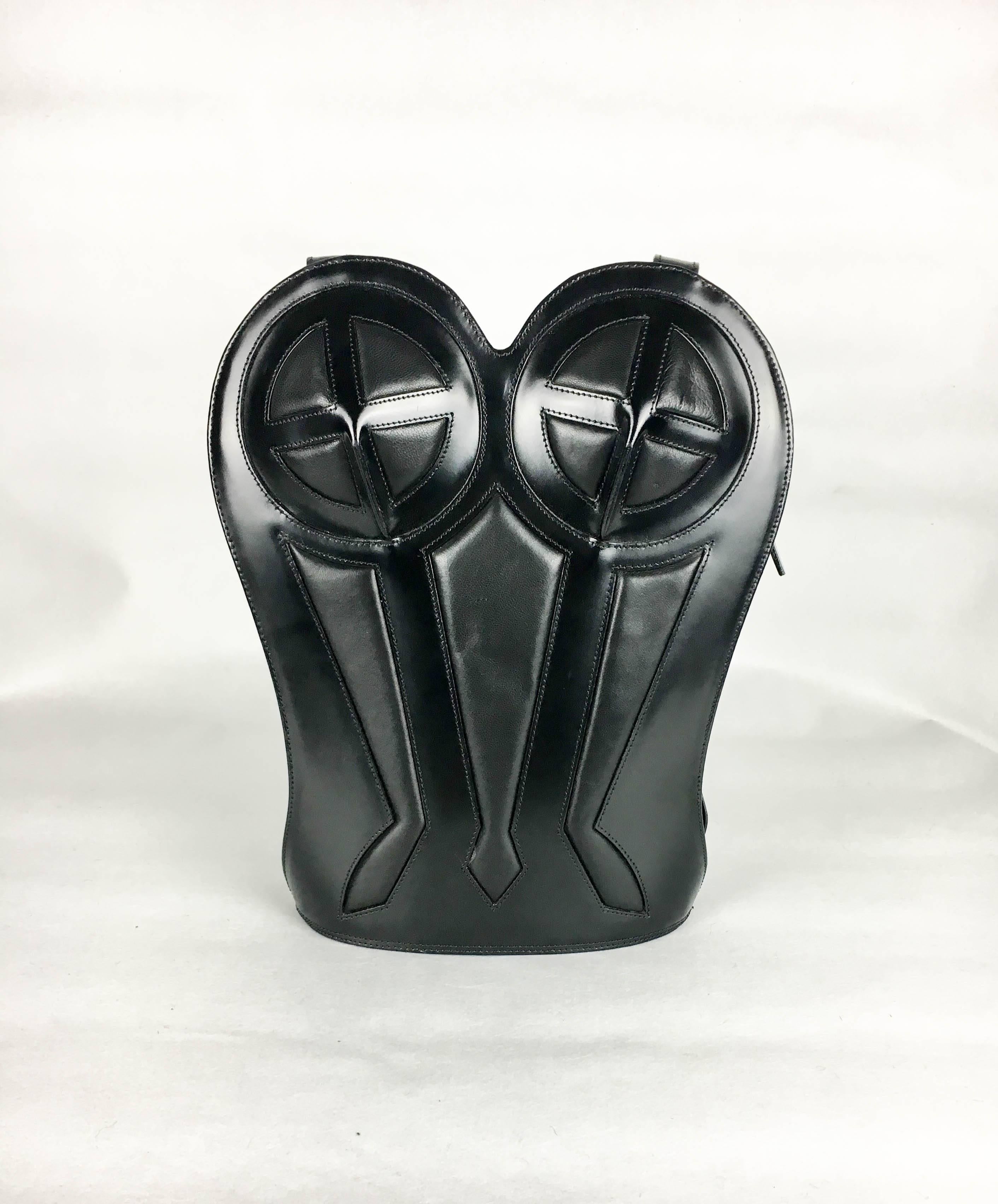 Vintage Jean Paul Gaultier Black Leather Bustier Backpack. This fabulous piece by Gaultier dates back from 1998. It has black hardshell shiny leather exterior and fabric lined interior. The design is inspired by the iconic bustier by Gaultier that
