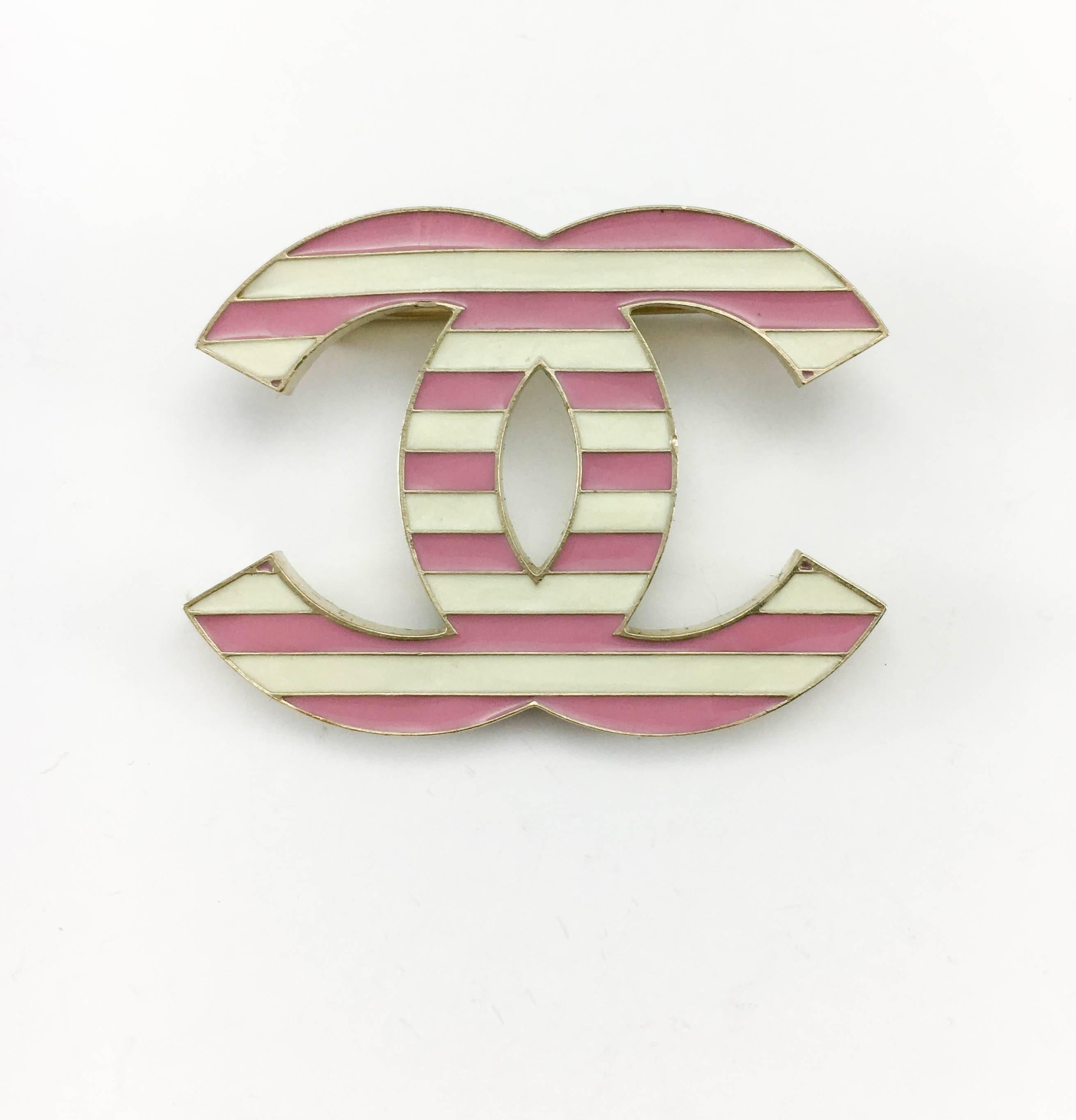 This pretty brooch by Chanel is part of the 2013 Cruise Collection. In the shape of the iconic ‘CC’ logo, it features pink and white enamelled stripes. The back and side of the brooch are made in matte gilt metal. Chanel signed on the back, it comes