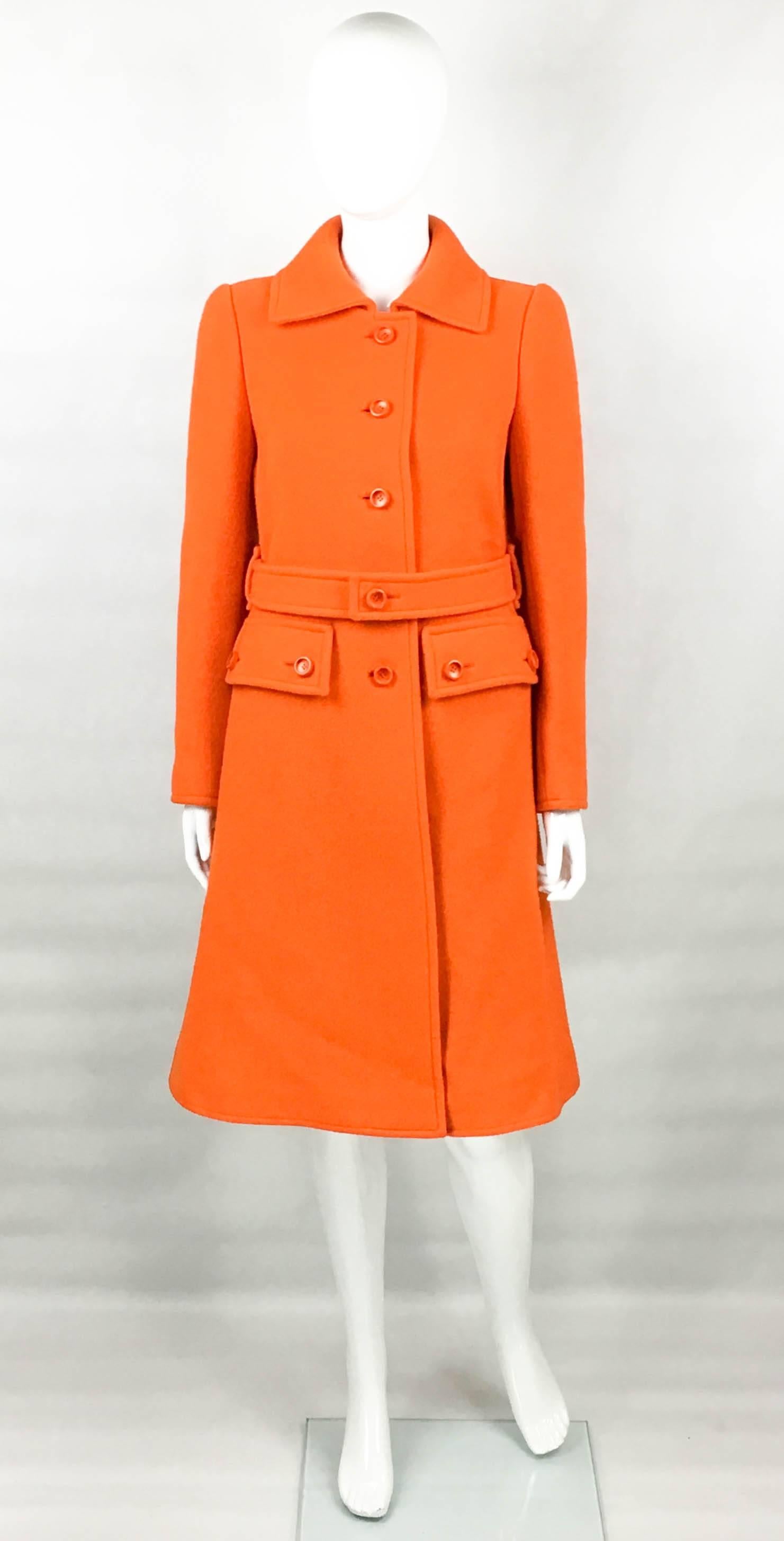 Vintage Courreges Orange Wool Coat. This gorgeous coat by Courreges dates back from circa 1970. Made in the iconic Courreges bright orange wool, it comes with a matching belt. There are 2 front pockets. It has 6 orange buttons down the front and 2