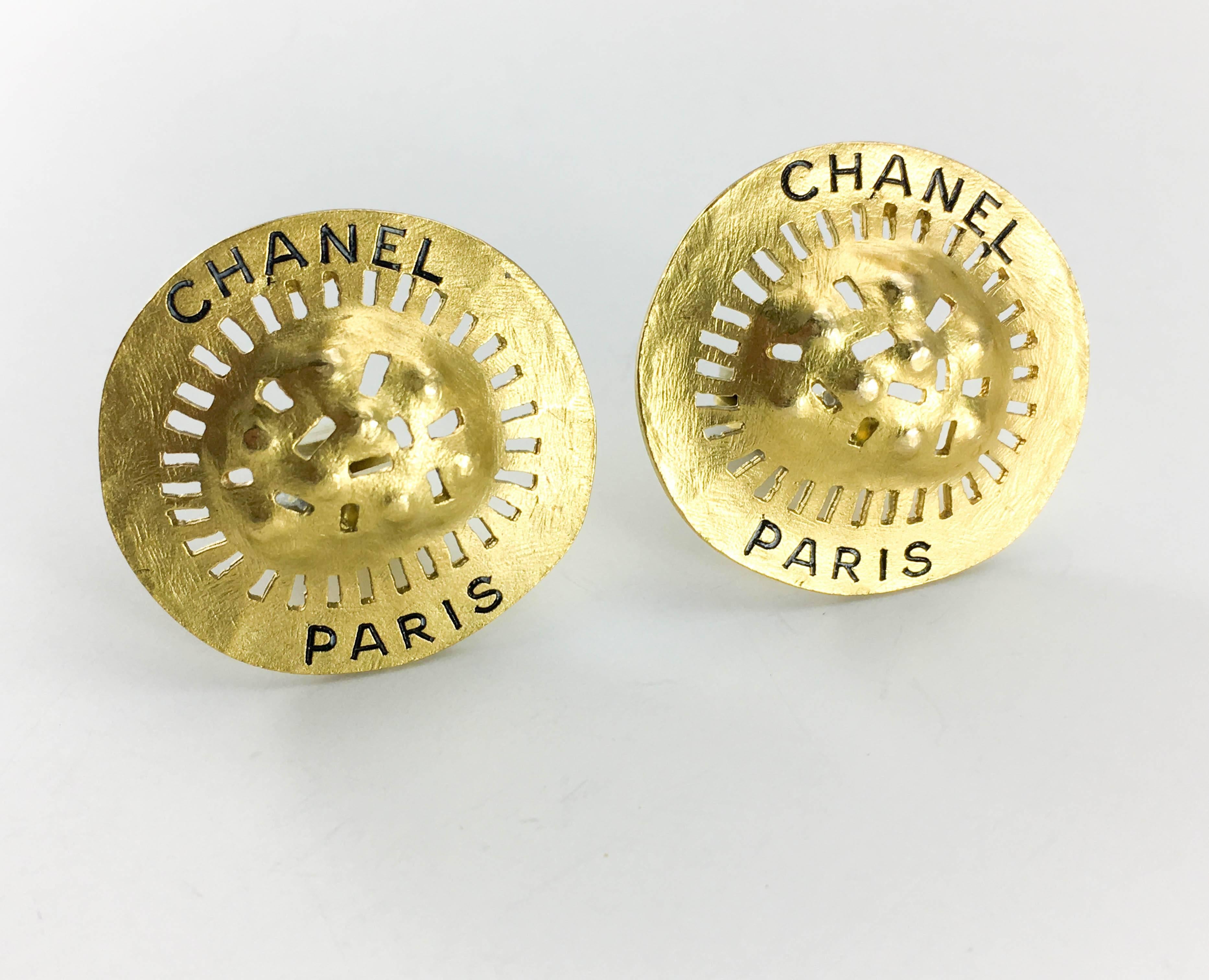 Vintage Chanel Gilt Clip-On Earrings. These striking earrings by Chanel are from the 1994 Spring / Summer collection. Made in gilt metal, the uneven design resembles a shield, with undulations and cut-outs, and read ‘Chanel Paris’. Chanel signed on