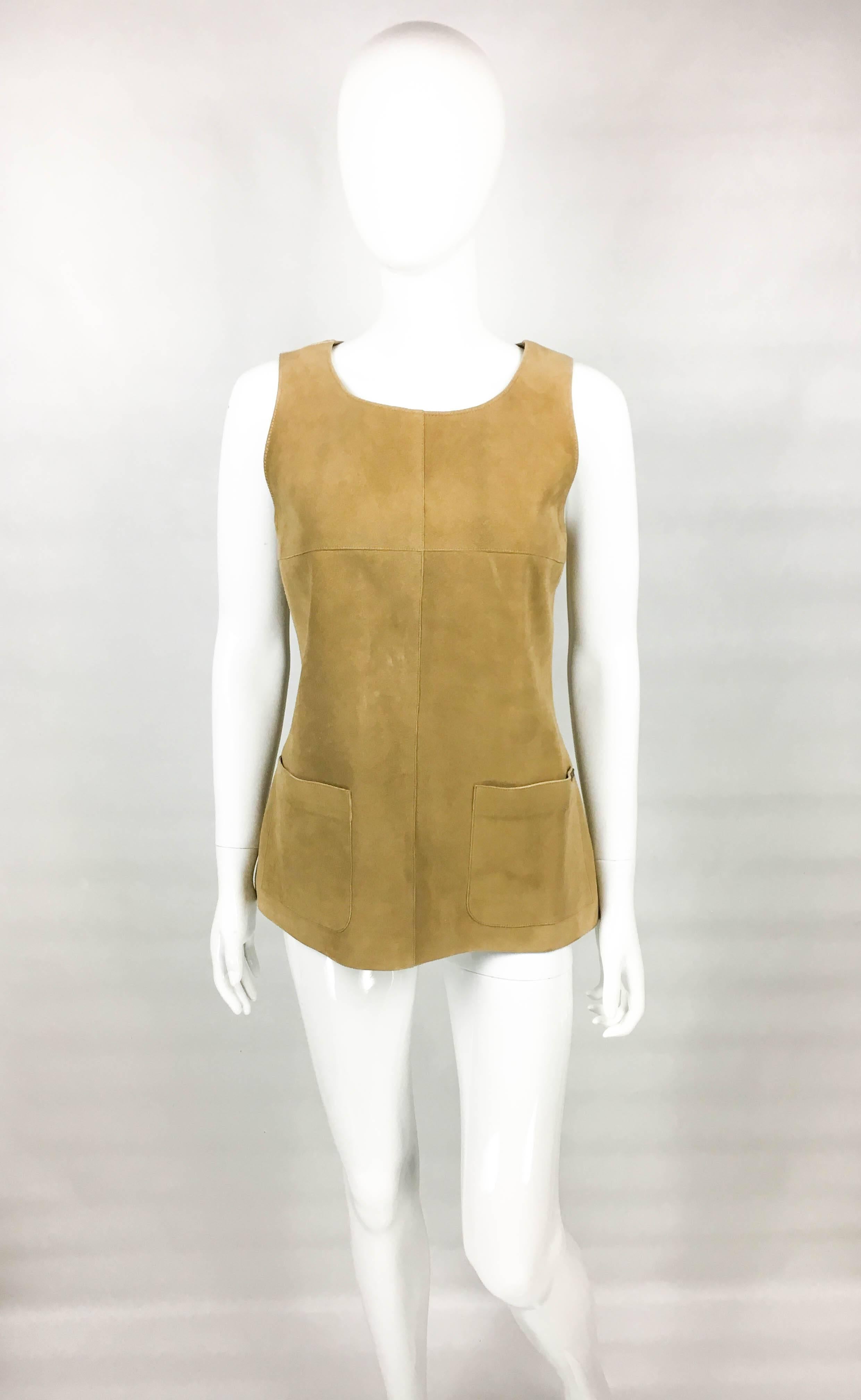 Vintage Chanel Tan Suede Gilet. This very elegant piece by Chanel was crafted for the 1999 Autumn / Winter Collection. Made in camel suede, it features 2 front pockets, with the left one bearing a Chanel metal tag. Back Zipper Closure. So