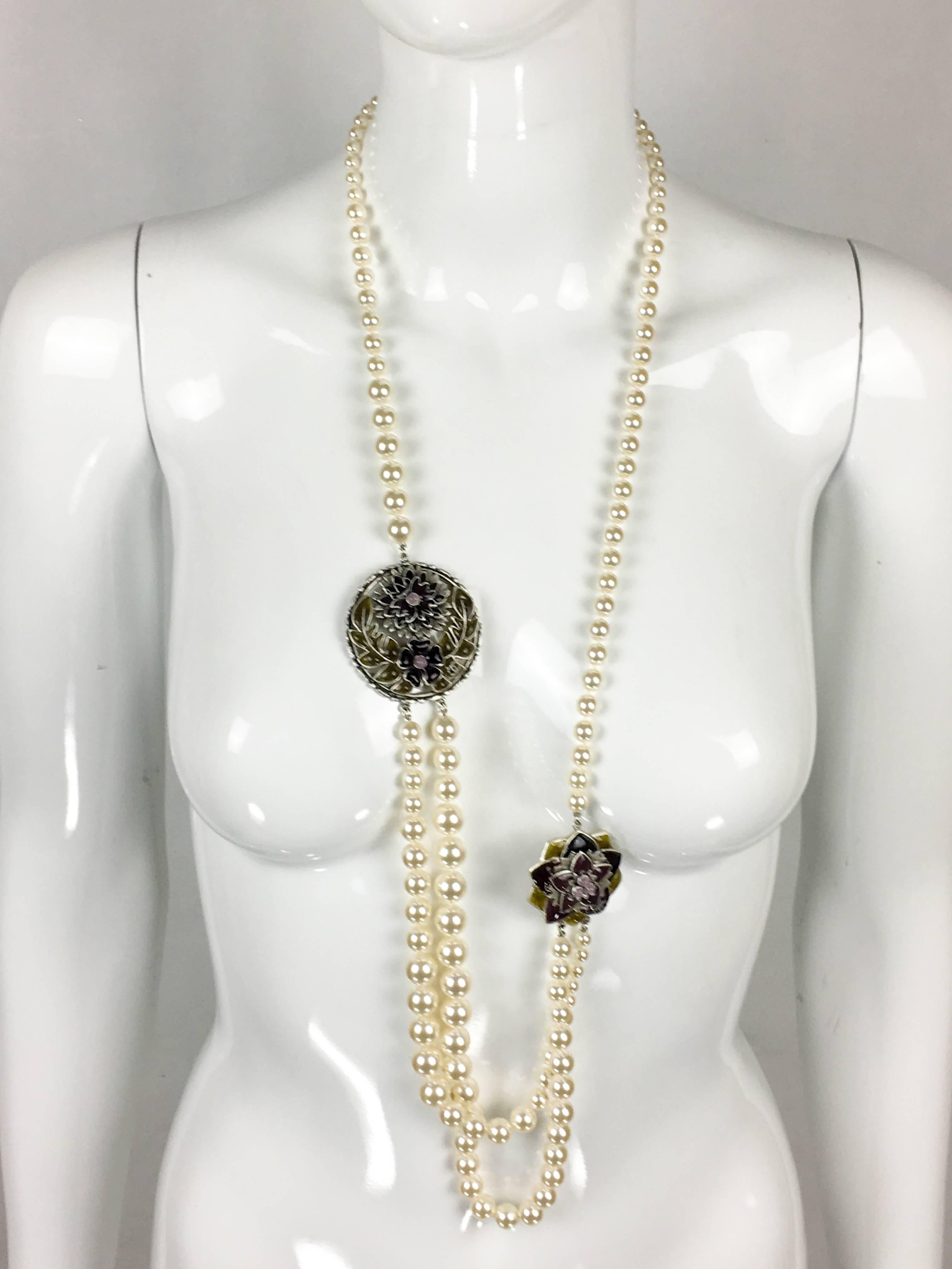 Chanel Pearl and Gripoix Sautoir. This gorgeous necklace by Chanel was crafted for the 2015 Autumn / Winter Collection. This long 2-strand graduated faux pearl sautoir features 2 medallions embellished with Gripoix (poured glass) creating floral