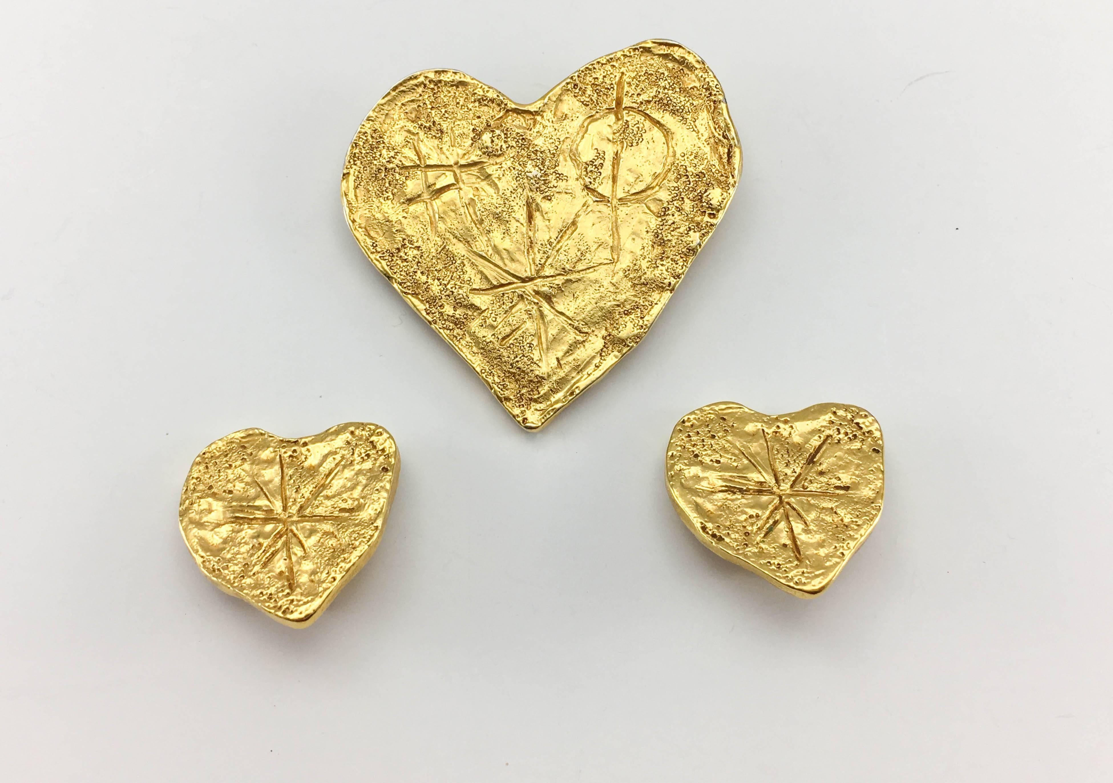 Vintage Christian Lacroix Gold-Plated Texturized Brooch and Earrings Heart Set. This striking set by Christian Lacroix by Goossens was created in 1994. Comprising of a pair of clip-on earrings and a brooch, the set bears a modernist design.