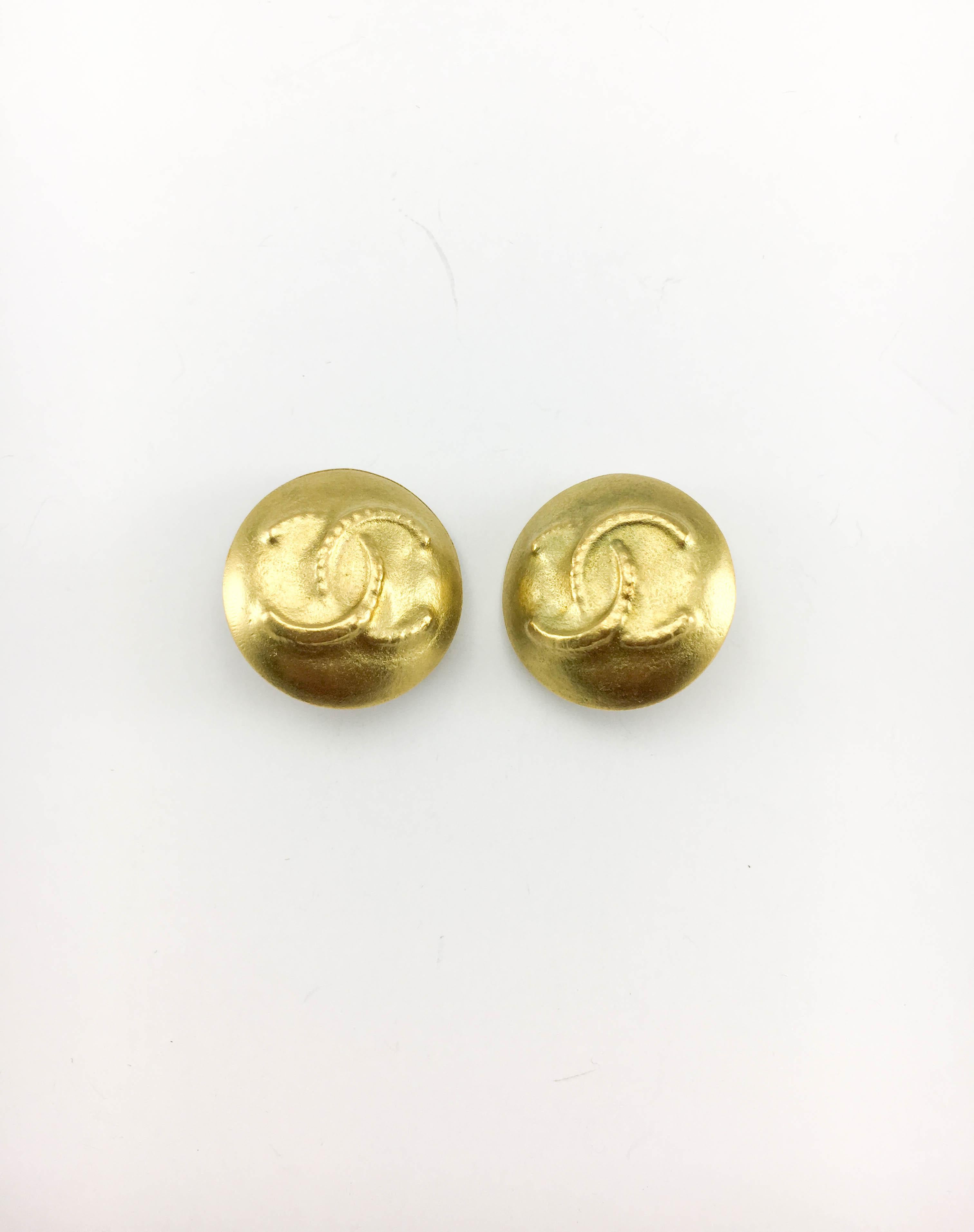 Vintage Chanel Gold-Tone Logo Clip-on Earrings. These lovely round earrings by Chanel were created for the 1995 Spring / Summer Collection. Gold-plated, they have a matte finish and feature the iconic ‘CC’ logo in the middle. Chanel signed on the