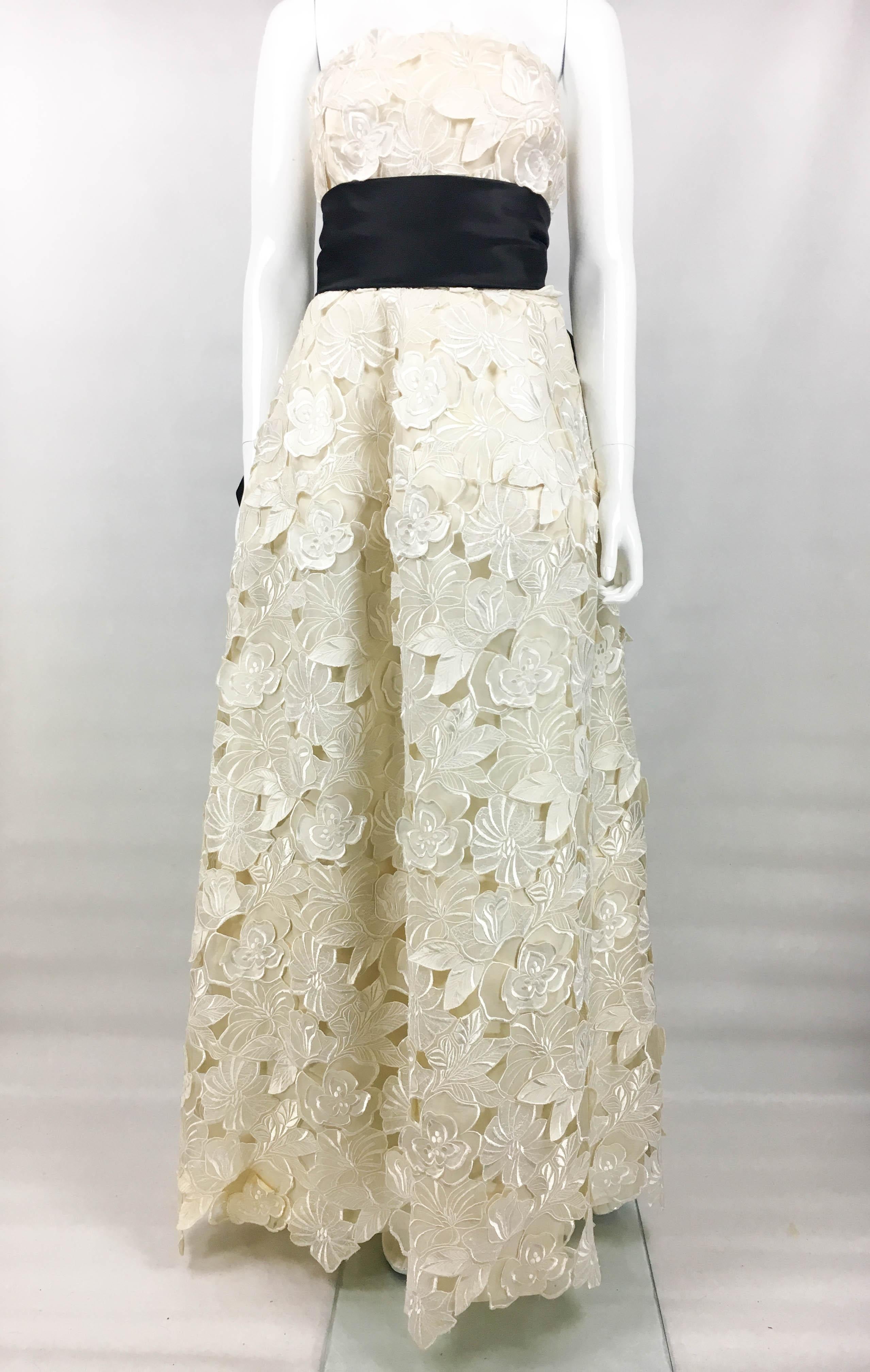 Vintage Givenchy Haute Couture Off-White Evening Gown. This stunning gown by Givenchy was crafted in 1985. Made in silk, it is over-layered with jacquard and embroidery flowers. The sleeveless design has a full floor-length skirt. Internally, it is