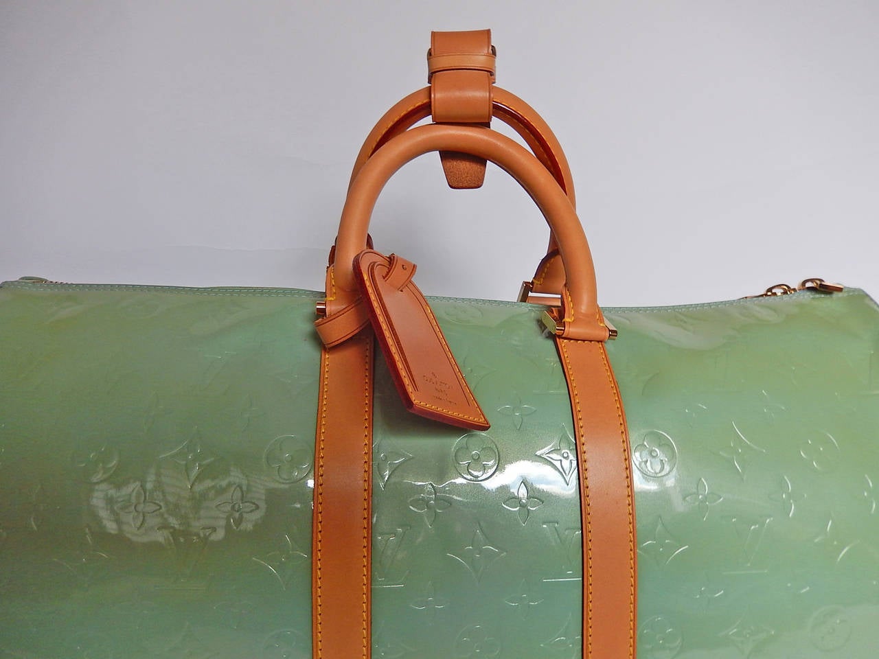 Mint blue/ green Vernis leather Louis Vuitton Keepall 45 with Vachetta leather trim, brass hardware, dual rolled handles, single interior zip pocket, single wall pocket and double LV zip closure.  Inside is all blue leather.
Handle Drop 5”, Height