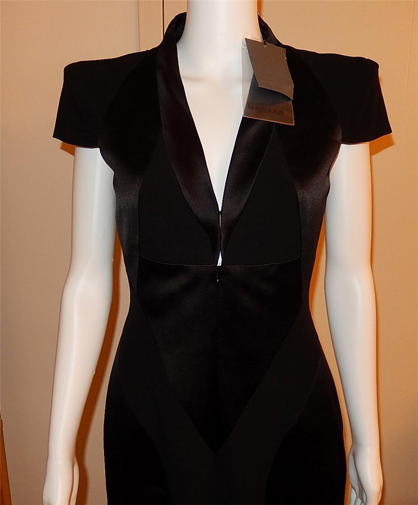 Brand new with tags, Alexander McQueen Black Dress

Padded cap shoulders

Dress zips up the front with two hook and eye closures above zipper

Material is 50% silk/28% rayon/21% acetate

Figure flattering panels to show off waist

Fully