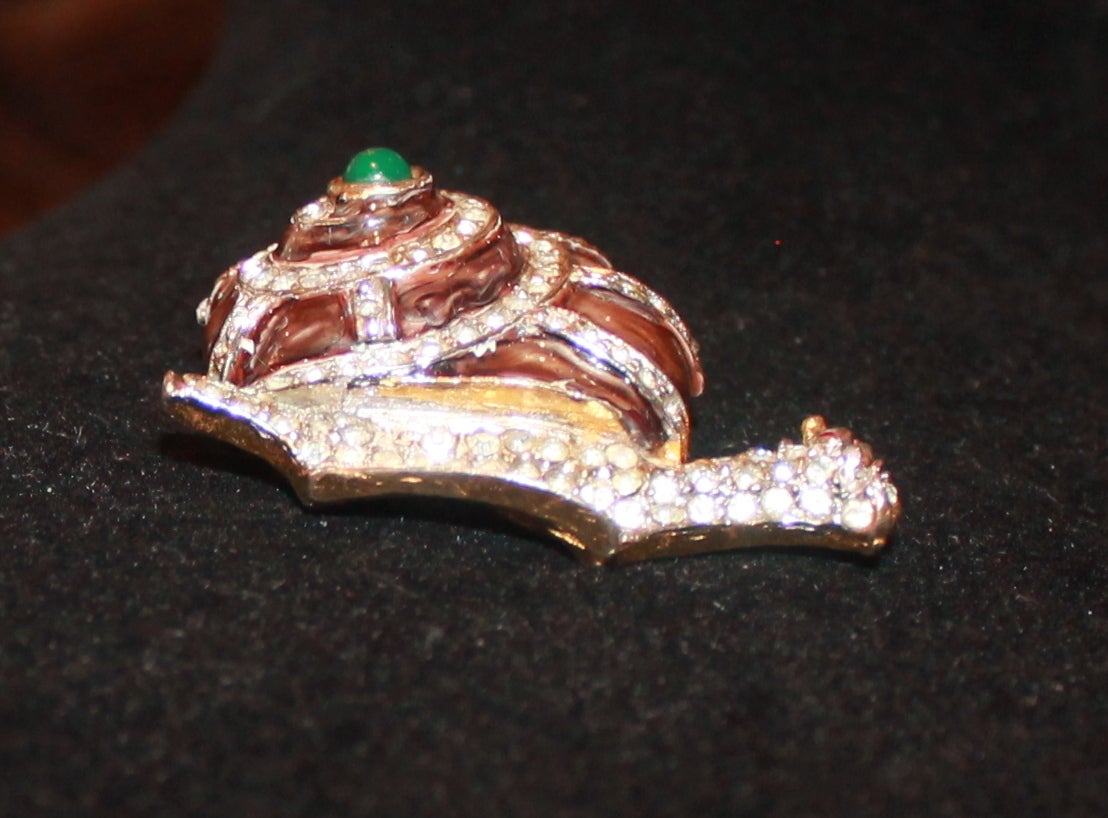Kenneth Jay Lane Vintage Brown Enamel Snail Brooch. This brooch is in very good vintage condition with rhinestones. There is a chip on the enamel on the top of the snail shell. 

Width- 1.5