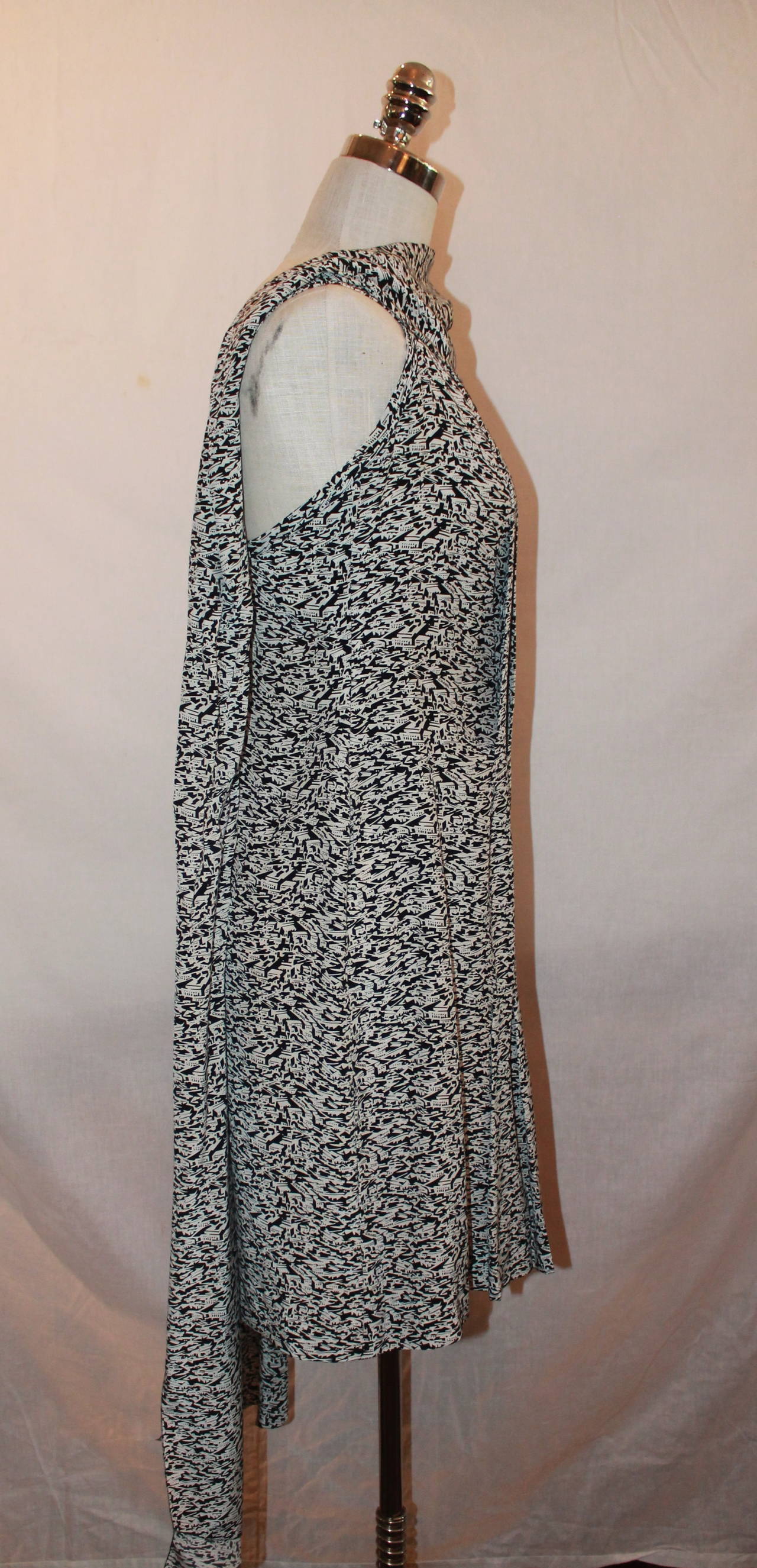 Chanel Black & White Printed Shawl Dress- 40. This dress is in excellent condition and has a print with geometric buildings. It is pleated with a shawl attached.

Measurements:
Bust- 34