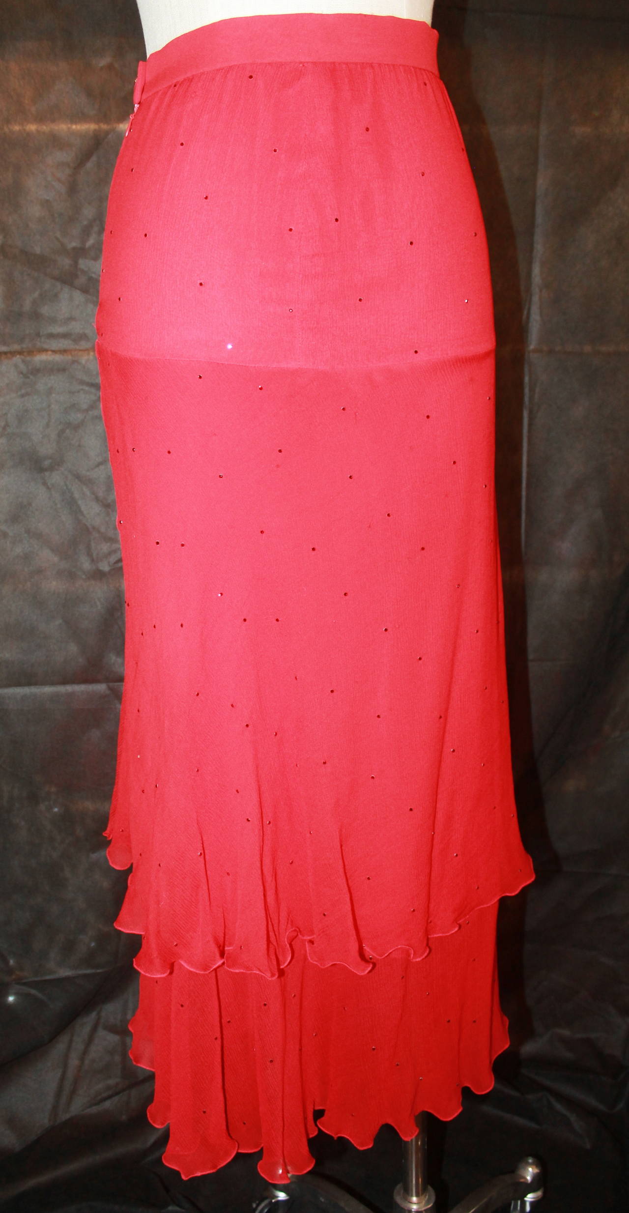 Chanel Vintage Red Silk Chiffon Tiered Skirt with Rhinestones - 2. This skirt is in very good condition with very minor signs of wear. It is from the 1980s.

Measurements:
Waist- 26"
Hips- 3"
Length- 36.5"