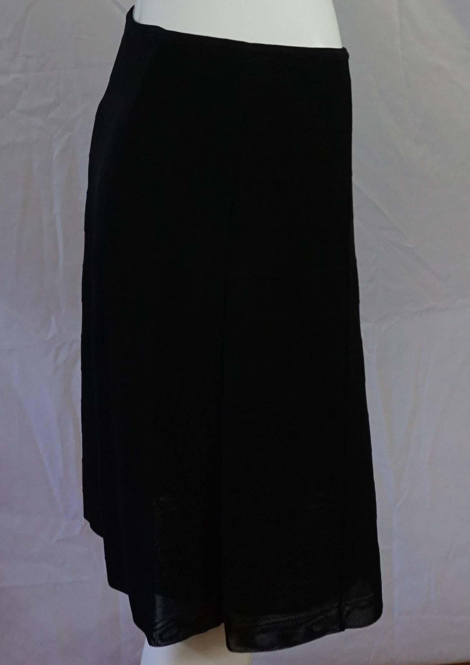 Chanel Black Knit 2 layer skirt - 44- 07c   This beautiful textured knit skirt has a nice stretch fabric made of viscose and rayon. It has a rectangular panel design in the knit, with a cc metallic logo on the left top waist area.  This skirt is in