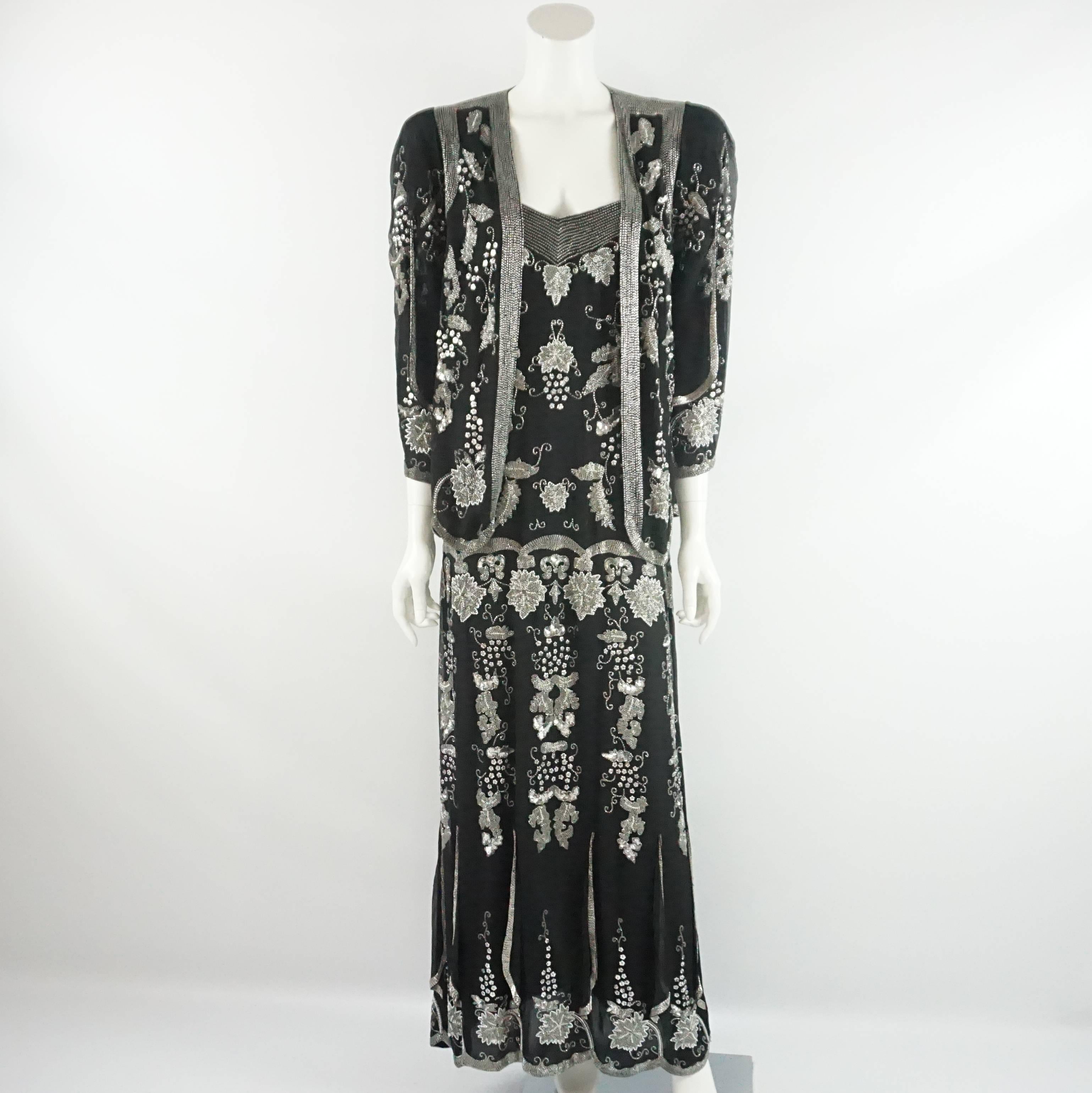 This vintage beaded dress is black with an intricate design of silver beads in an art deco style. It has spaghetti straps and a matching jacket. The jacket has no closure and a scallop hem. These pieces are in very good vintage condition with some