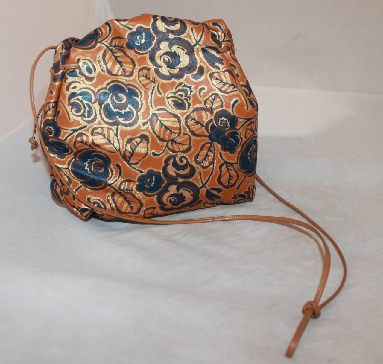 Carlos Falchi 1970's Camel Floral Print Leather Crossbody Bag. This bag is in very good condition vintage condition with wear consistent with its age. The strap can be adjusted by tying the knot higher and lower.

Measurements:
Length-