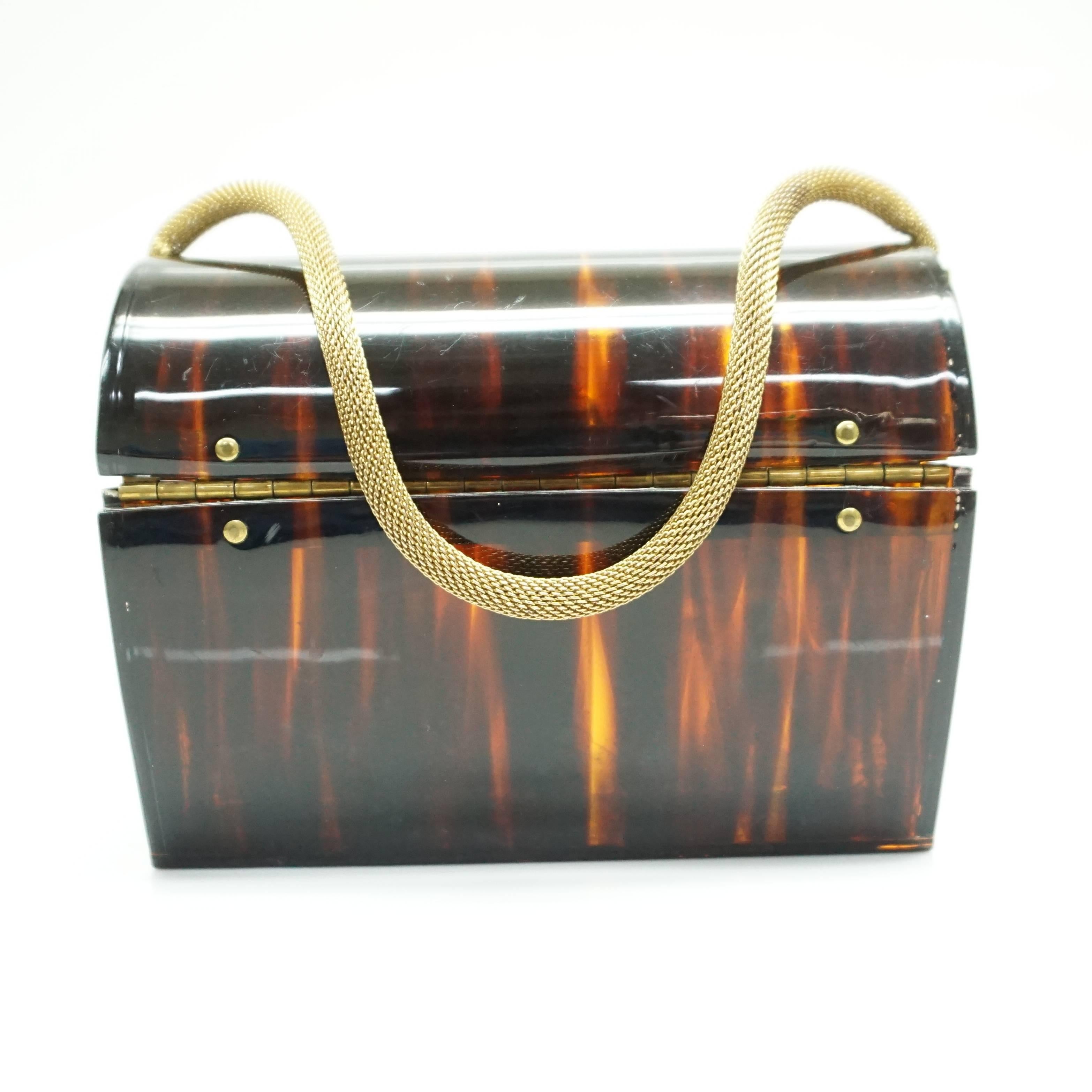 Wilardy Tortoise Lucite Handbag - Circa 60's  This spectacular tortoise lucite handbag has one main compartment. Has a gold round metal mesh strap and a front circular lucite with gold trim closure. The bag is in very good vintage